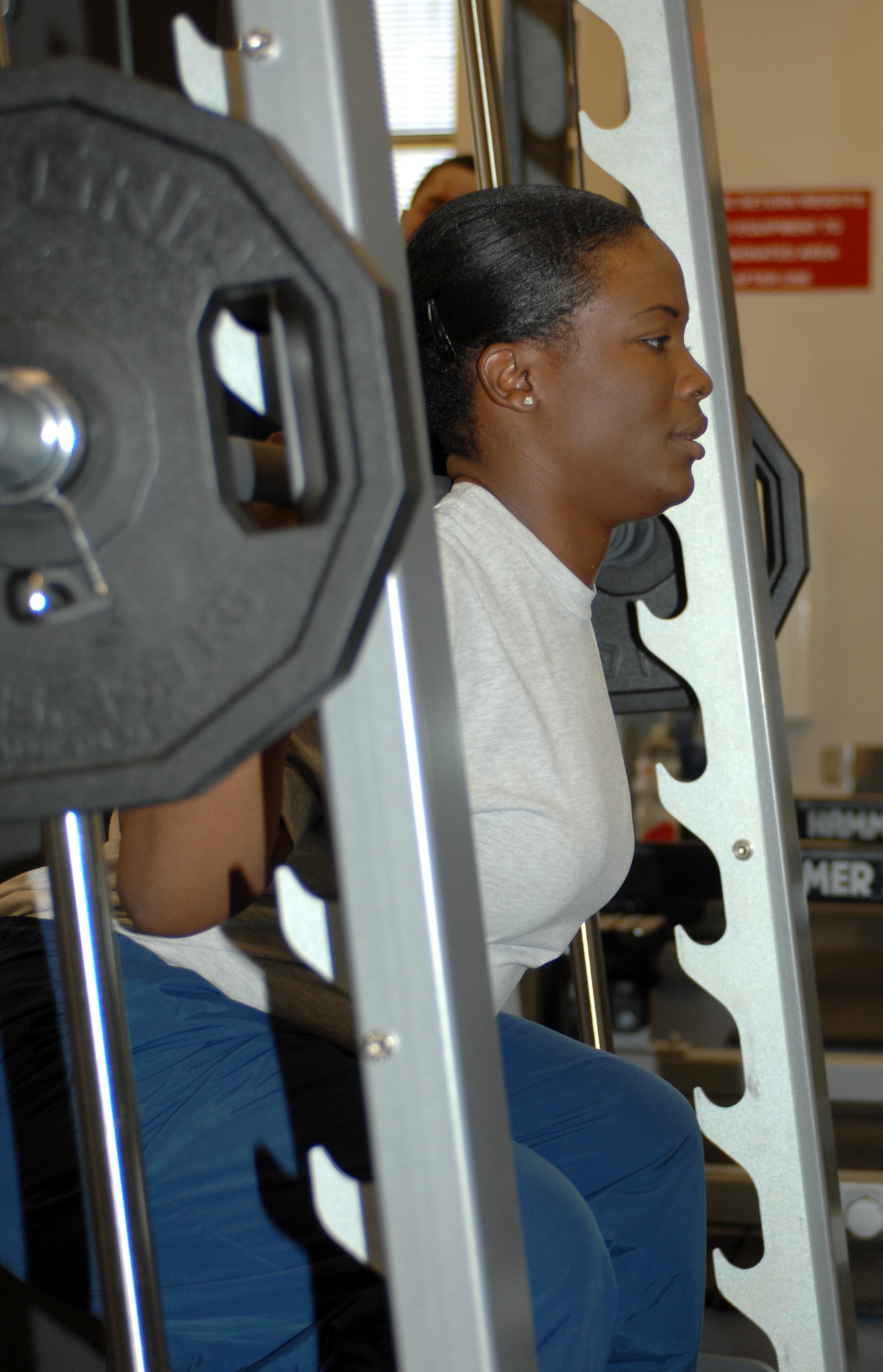U.S. Air Force Senior Airman Kellie Jones, 355th Force Support Squadron fitness specialist, works out her legs as she performs squats at the Benko Fitness Center on Davis-Monthan Air Force Base, Ariz. Jan. 19. The Benko Fitness Center keeps Airmen fit to fight. (U.S. Air Force photo by Airman 1st Class Michael Washburn/Released)