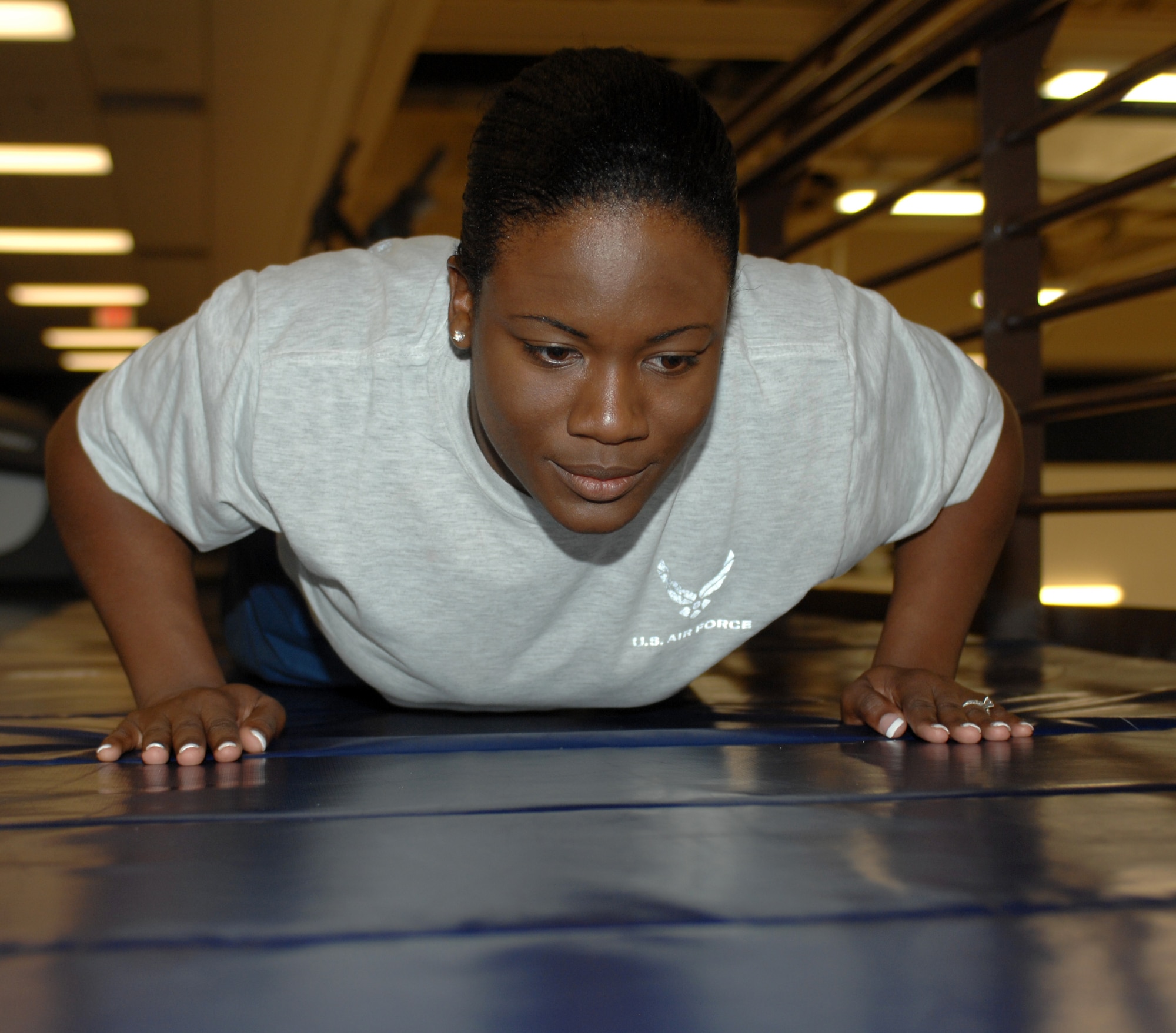 U.S. Air Force Senior Airman Kellie Jones, 355th Force Support Squadron fitness specialist, practices her push-ups during her workout at the Benko Fitness Center on Davis-Monthan Air Force Base, Ariz. Jan. 19. The Benko Fitness Center keeps Airmen fit to fight. (U.S. Air Force photo by Airman 1st Class Michael Washburn/Released)