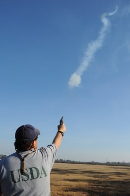 Dennis Lewis shoots a banger toward a group of birds during a wildlife patrol on Seymour Johnson Air Force Base, N.C., Jan. 20, 2012. U.S. Department of Agriculture specialists search the base flightline for wildlife everyday to prevent damage to aircraft and to maintain the F-15E Strike Eagle flying schedule. Aircraft cannot land or take off if there is too much wildlife on the flightline. Lewis is a USDA specialist from Milan, Tenn. (U.S. Air Force photo/Senior Airman Whitney Stanfield)