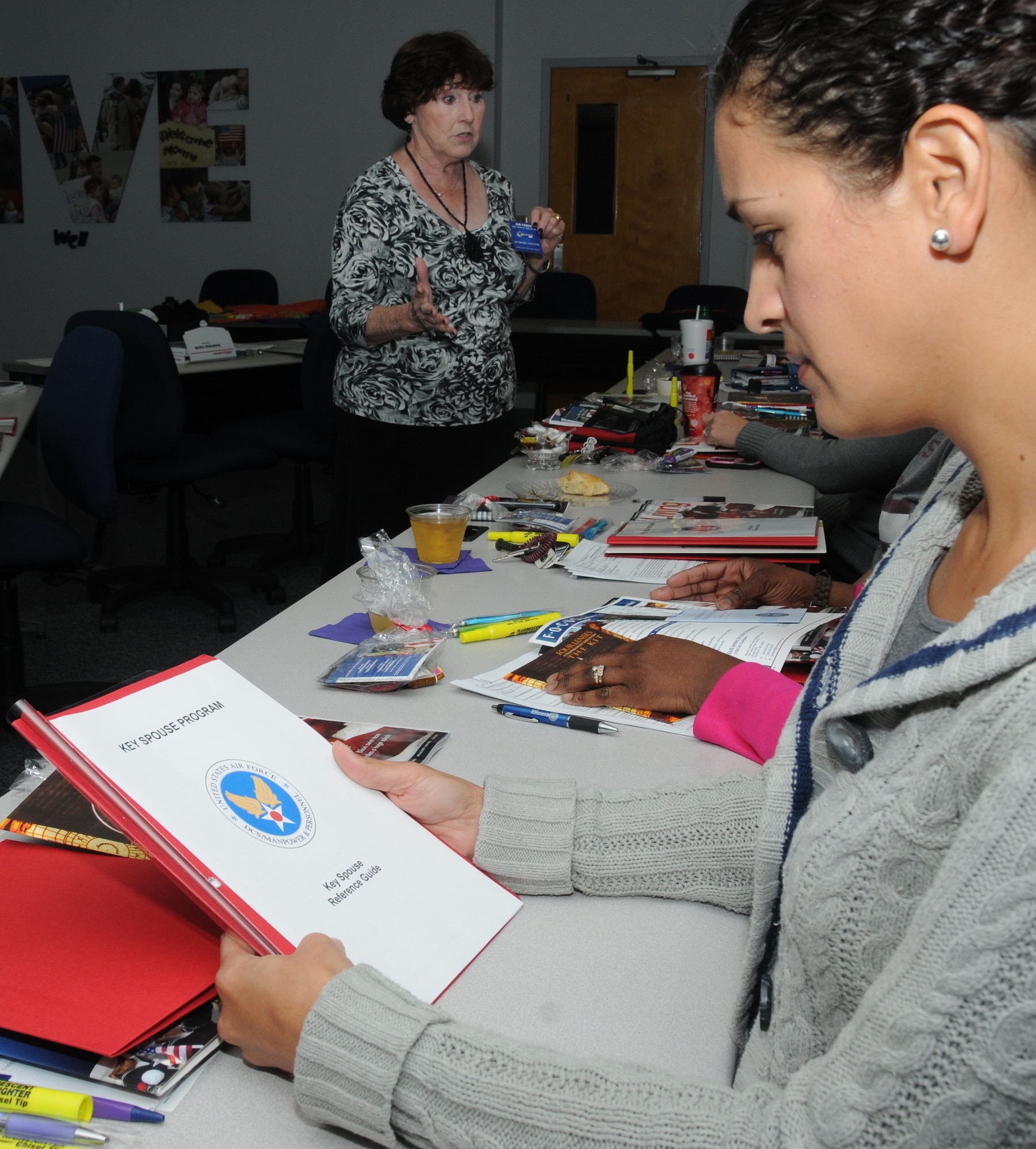 Becky Stanley, the airman and family readiness center’s personal and family life program manager, discusses the significant role of a key spouse as  Lily Williams reads a pamphlet during Key Spouse training at the Sablich Center at Keesler Air Force Base, Miss., Dec. 12, 2011. The Key Spouse program is the commanders’ and first sergeants’ link to get information to the spouses and families of squadron or unit members. A Key Spouse volunteers to represent and be the point of contact for a squadron and is charged with making sure important information gets communicated.  (U.S. Air Force photo by Kemberly Groue)