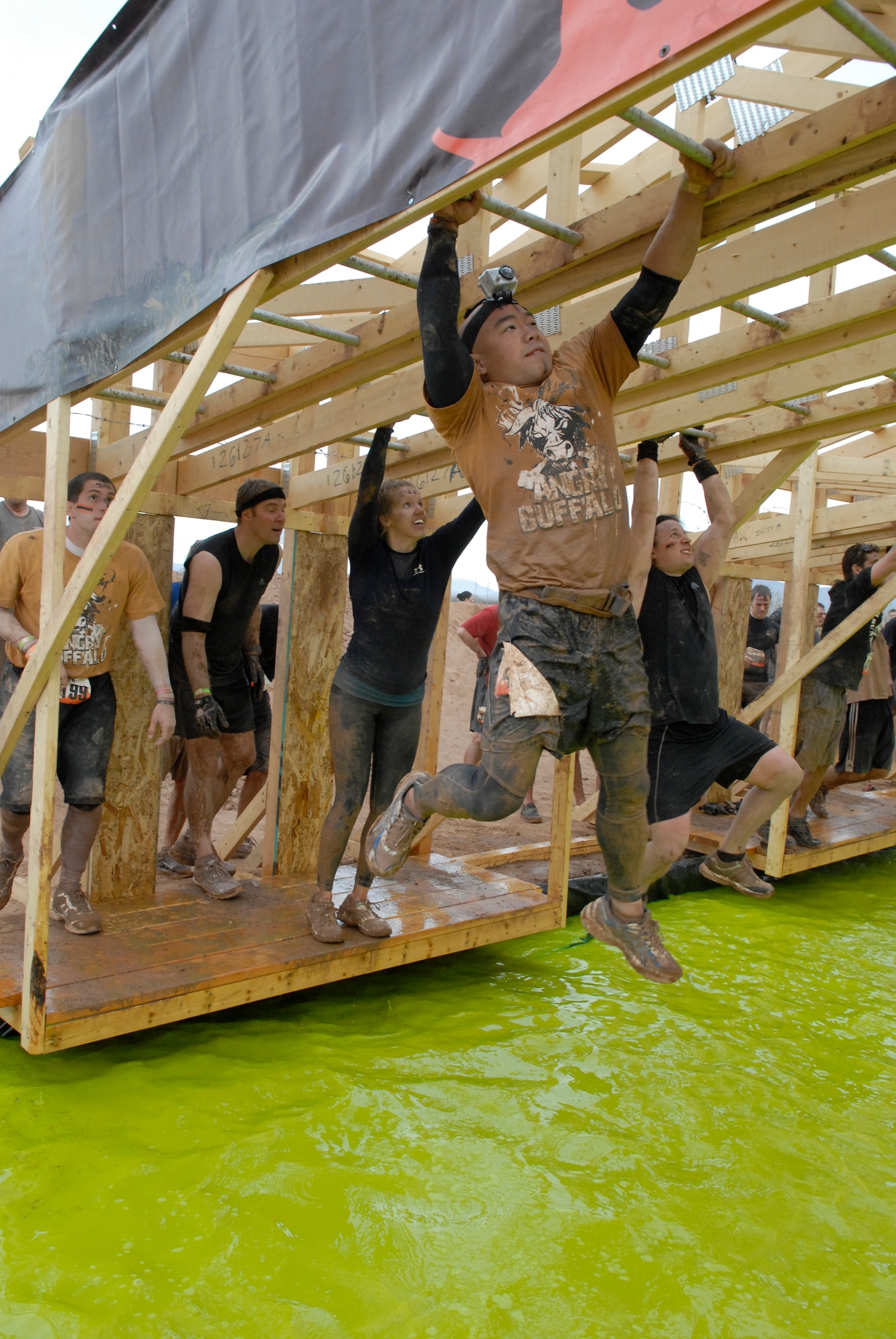 Staff Sgt. Dan Mach, 607th Air Control Squadron technician flight chief, Luke Air Force Base, Ariz., climbs the monkey bars Jan. 14 during the Tough Mudder at the Mesa Proving Grounds in Mesa, Ariz. This was the second to last obstacle the participants did during the course. (U.S. Air Force photo by Airman 1st Class David Owsianka)