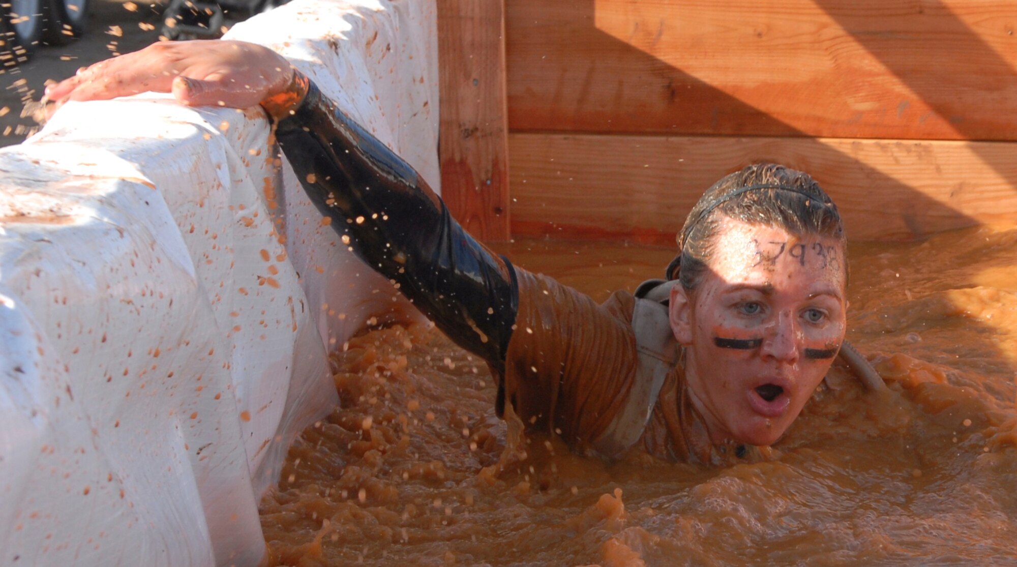 Senior Airman Stephanie Harp, 56th Security Forces Squadron, Luke Air Force Base, Ariz., grabs onto the wall after coming up for air during the Tough Mudder arctic enema obstacle. (U.S. Air Force photo by Airman 1st Class David Owsianka)