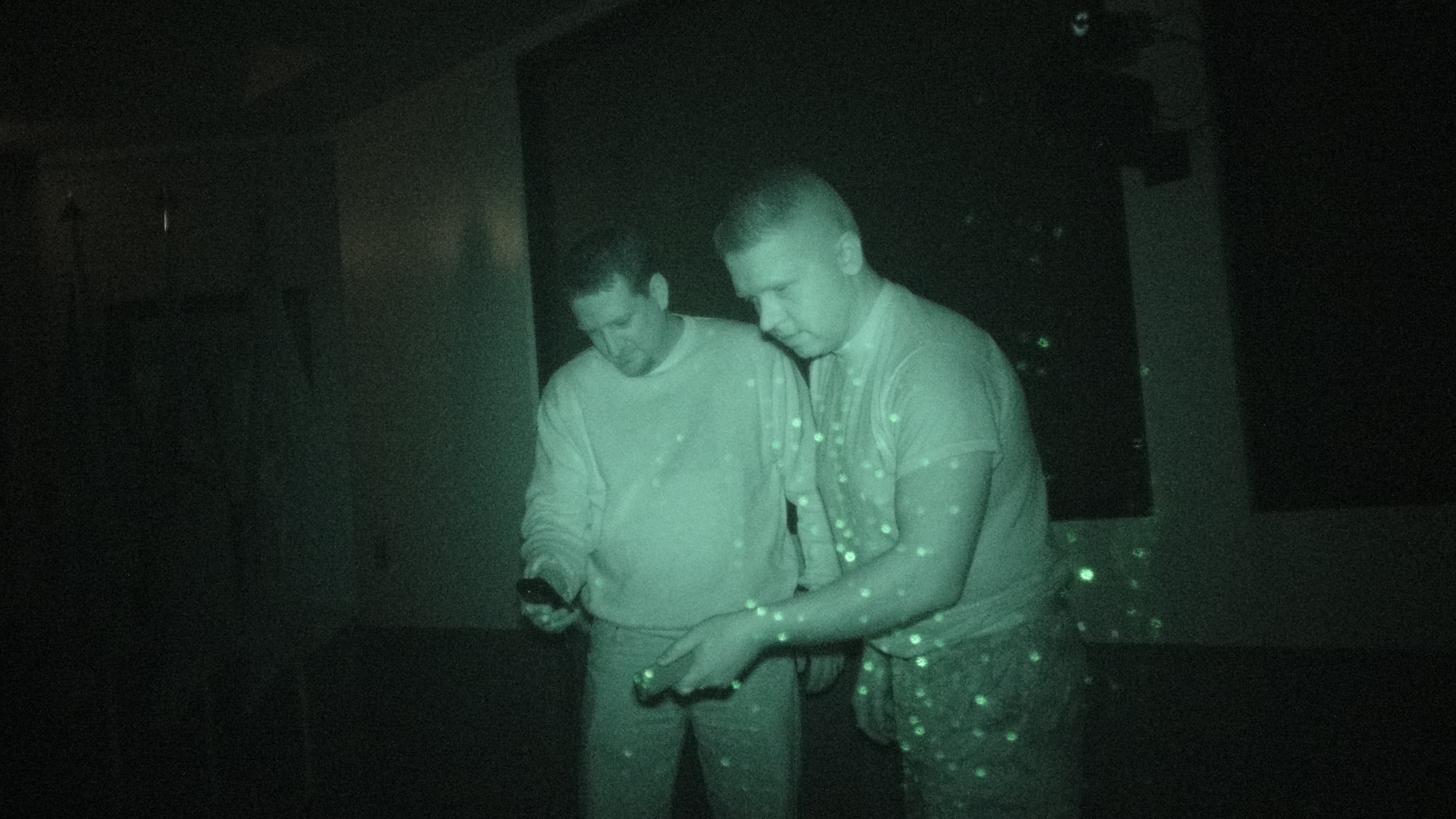 Josh Burger and Stan Maczek demonstrate the use of an electro-magnetic field detector through the lense of a video camera equipped with an infrared attachment. Burger and Maczek use both instruments during their paranormal investigations. (U.S. Air Force photo\Scott Prater).