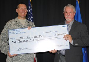 Col. Paul Nelson, 480th Intelligence, Surveillance and Reconnaissance Wing commander, presents a $10,000 check to Peter McEntire for the Air Force Innovative Development through Employee Awareness Program Jan. 18, 2012. McEntire, 480th ISR systems integration chief, designed and built a metal, separation shield for junction boxes to house classified and unclassified fibers, saving the Air Force more than half a million dollars annually. (U.S. Air Force photo by Marge McGlinn/Released)