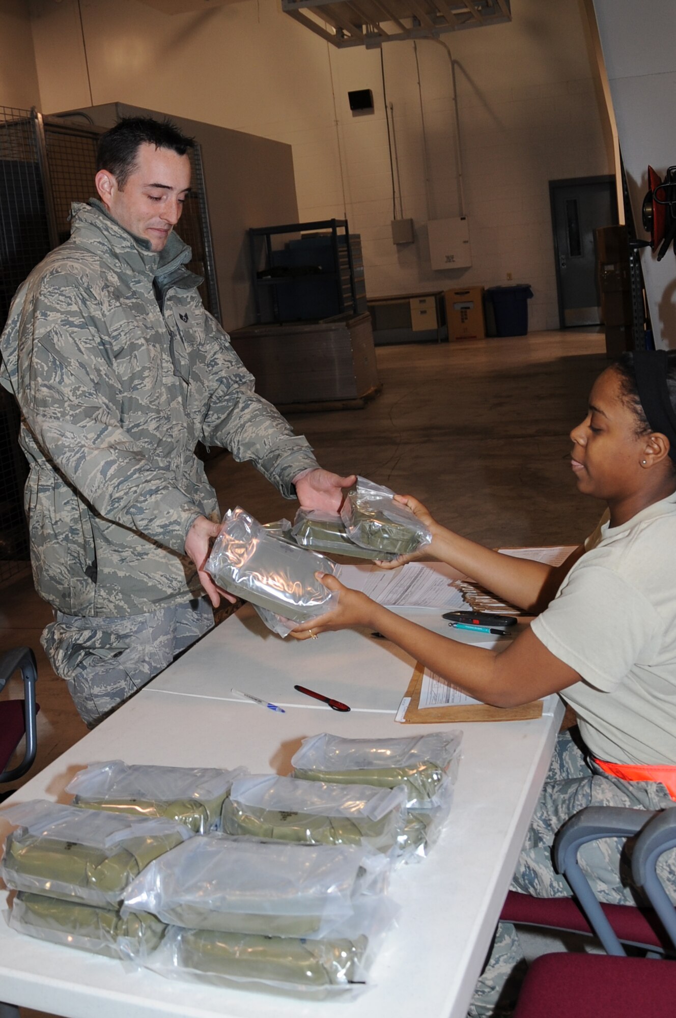 Staff Sgt. Joseph Barnard, 442nd Maintenance Squadron crew chief, receives deployment gear from Senior Airman Brittany Jackson, 442nd Logistics Readiness Squadron supply technician, Jan. 22, 2012. Barnard, will be one of 360 reservists from the 442nd Fighter Wing, who will deploy this year in support of Operation Enduring Freedom. The 442nd FW is an A-10 Thunderbolt II Air Force Reserve unit at Whiteman Air Force Base, Mo. (U.S. Air Force photo/Staff Sgt. Lauren Padden)