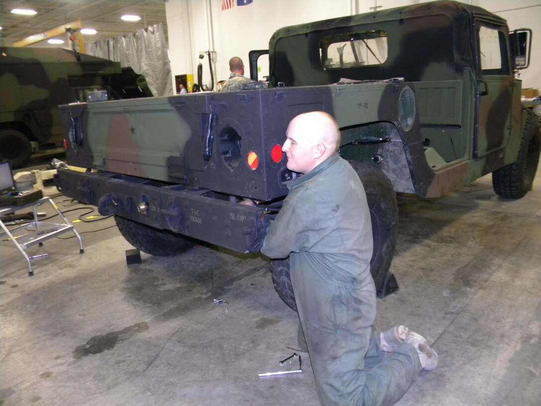 U.S. Army Specialist Eric Papineau, 7th Sustainment Brigade wheeled vehicle mechanic, tears down a High Mobility Multi Wheeled Vehicle at AM General's Research and Development plant in Livonia, Mich., in Dec. 2011. Soldiers took part in a vehicle maintenance upgrade program that will improve the process for years to come. (Courtesy photo)