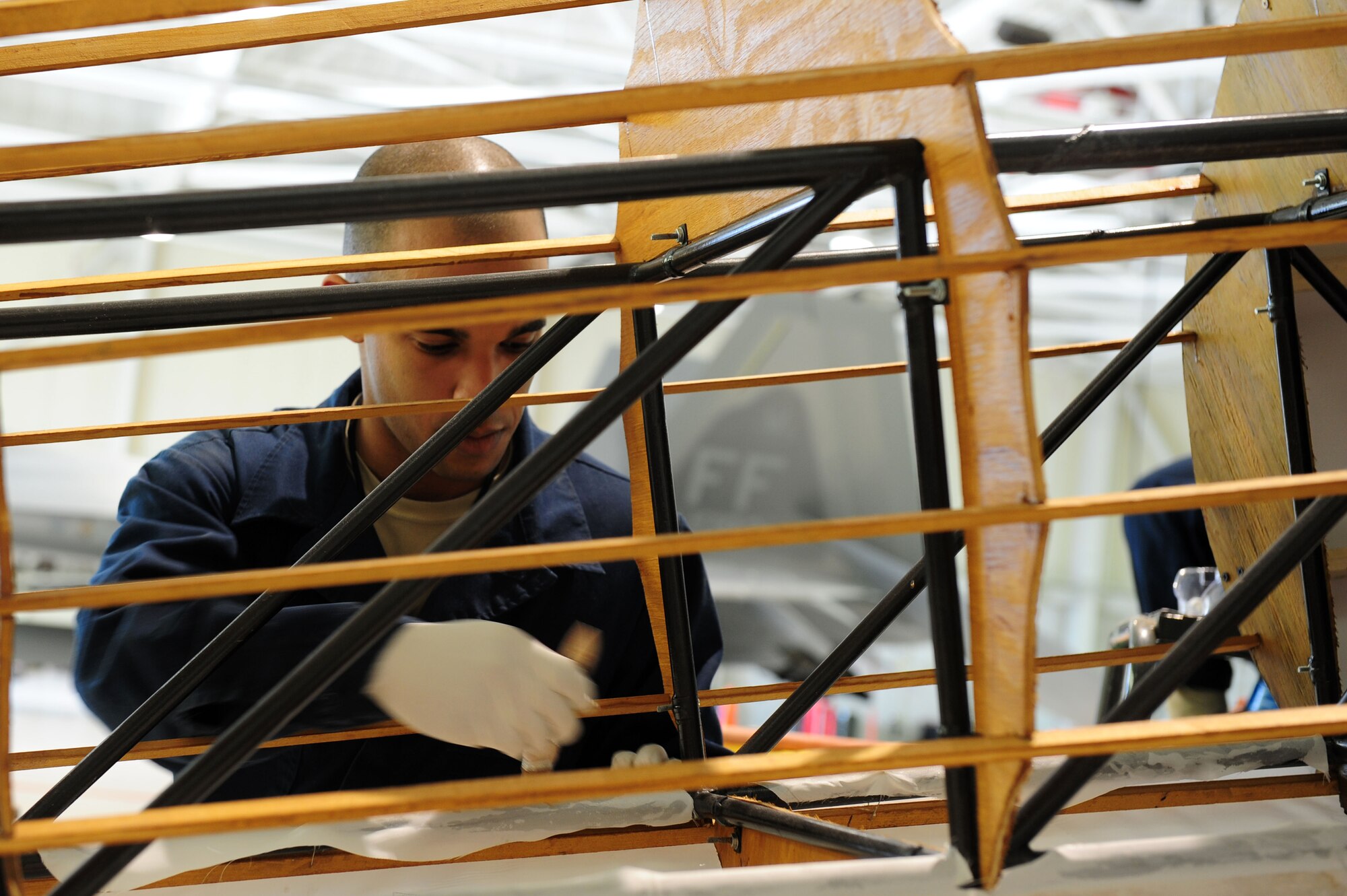 U.S. Air Force Airman 1st Class Ismael Debarros, 94th Aircraft Maintenance Unit F-22 Raptor crew chief, takes part in rebuilding the  Niueport 28 replica at Langley Air Force Base, Va., Jan. 17, 2012.  The original replica of the Niueport 28 was destroyed by a storm on May 24, 2011.  (U.S. Air Force photo by Airman 1st Class Kayla Newman/Released) 