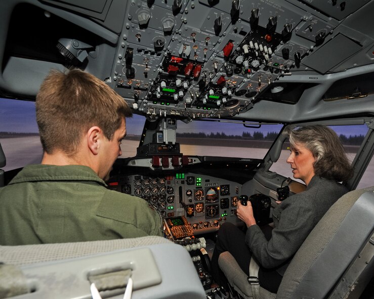Maj. William Hartman, 330th Combat Training Squadron instructor pilot, gives instructions to Kathy Wells, wife of 9th Air Force Commander Maj. Gen. Lawrence Wells,  as she flies the E-8 Joint STARS simulator, Robins Air Force Base, Ga., Jan. 17, 2012.  Wells toured the simulator during a two-day visit to the 461st and 116th Air Control Wings with her husband.  This was Maj. Gen. Wells' first visit to  JSTARS since the activation of the 461st ACW.  (Air National Guard photo by Master Sgt. Roger Parsons/Released)
