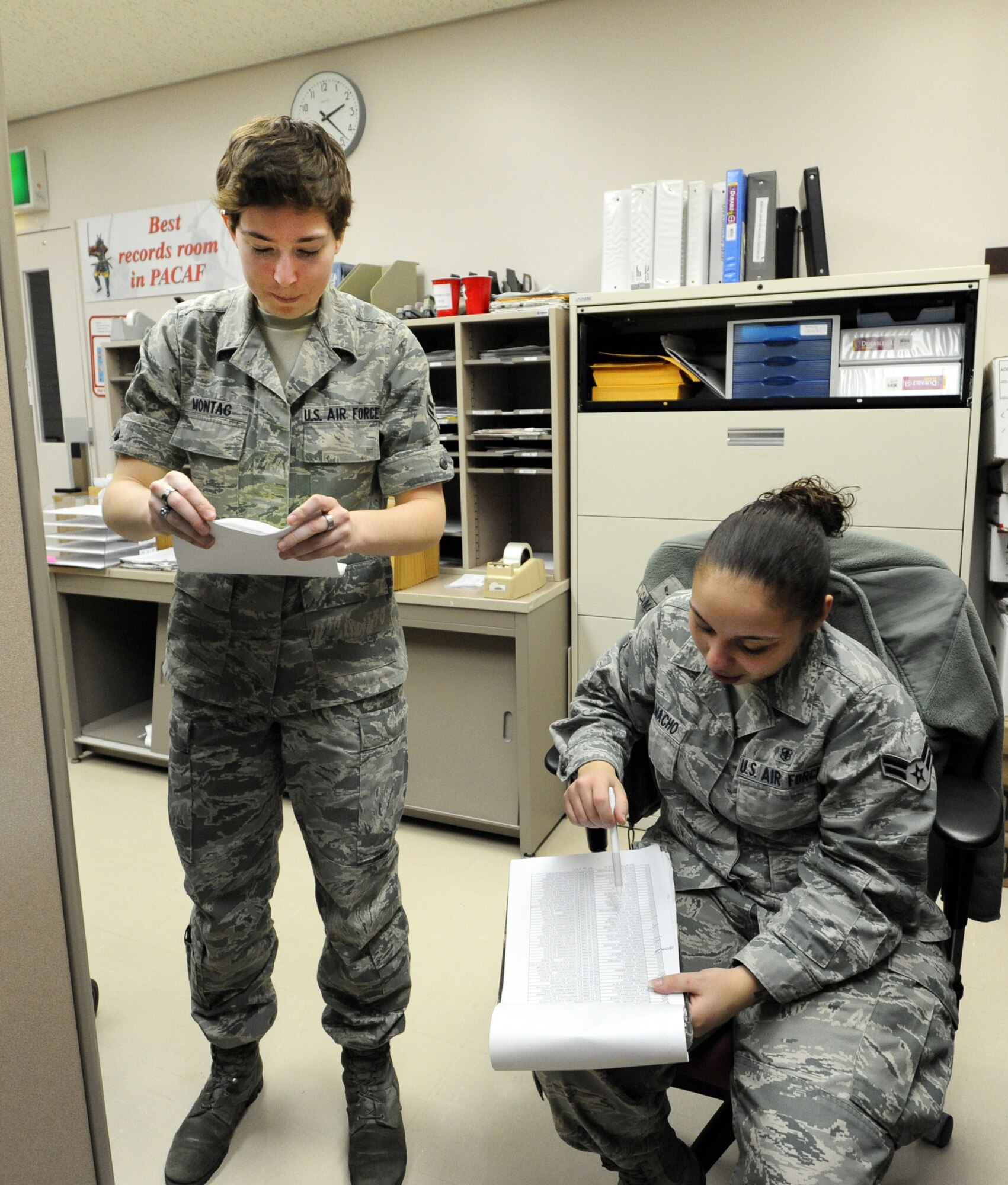 MISAWA AIR BASE, Japan -- Airmen 1st Class Kaitlin Montag, left, and Nicole Camacho, right, 35th Medical Support Squadron outpatient records technicians, compare record's lists during an audit here, Jan. 19. Members of the outpatient records team are assigned sets of records which they are responsible for. To maintain organized filing, records are color coded according to their number. (U.S. Air Force photo/Airman 1st Class Kia Atkins)