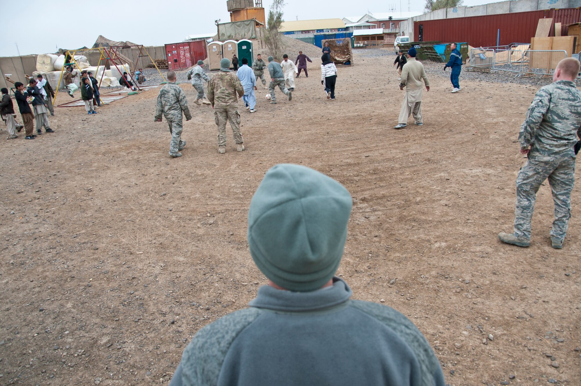 KANDAHAR AIRFIELD, Afghanistan -- Airmen from the 451st Air Expeditionary Wing play soccer against the bazaar school children at Kandahar Airfield, Afghanistan Jan. 21, 2012. In a friendly game between the two teams, the 451st AEW team won 1-0. (U.S. Air Force photo by Staff Sgt. David Carbajal)