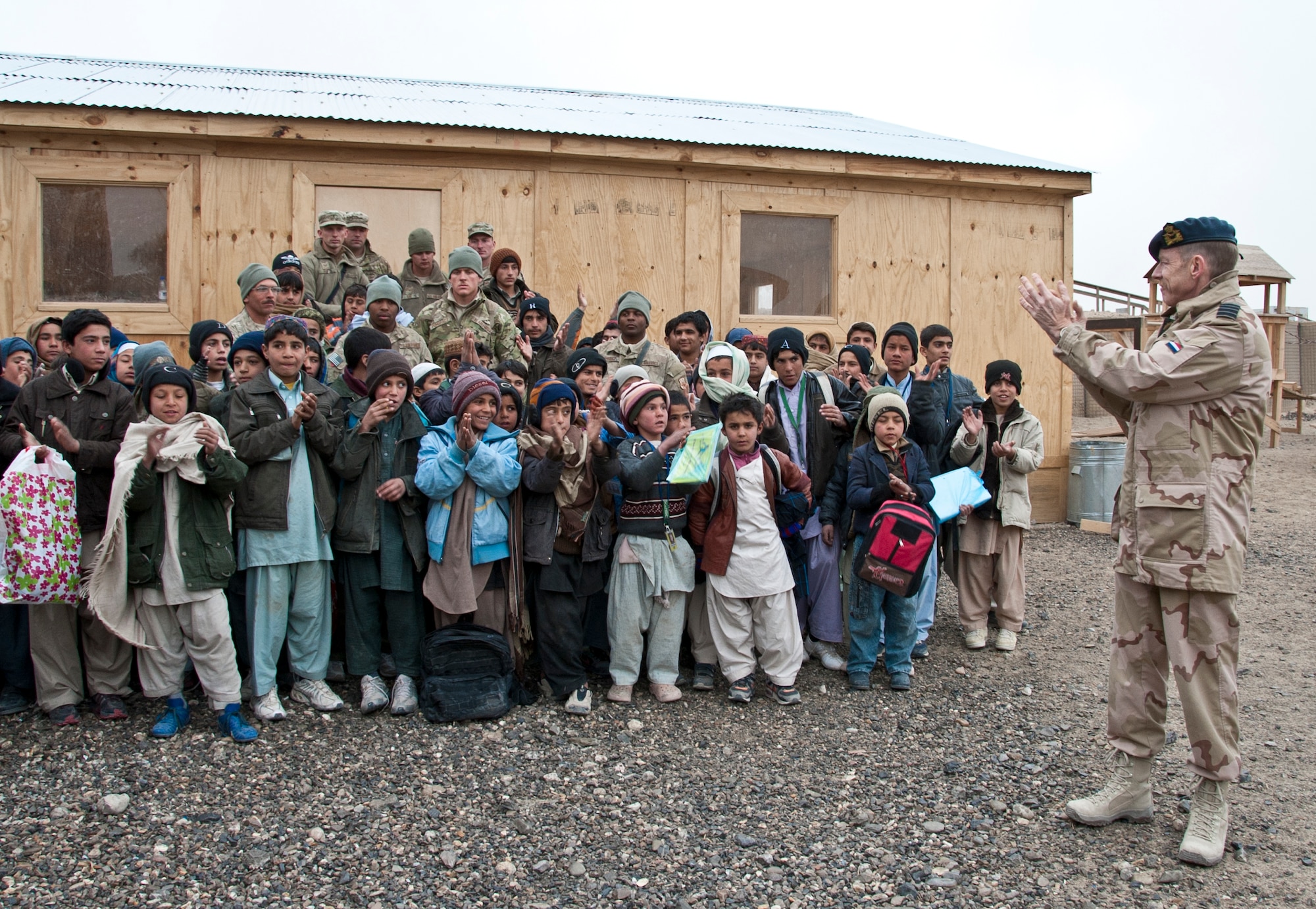 KANDAHAR AIRFIELD, Afghanistan -- Netherlands Col. Kees Marselis, Kandahar Airfield chief of staff, applauds the bazaar school children for continuing their education and wishes them a prosperous future during the bazaar school ribbon-cutting ceremony at Kandahar Airfield, Afghanistan Jan. 21, 2012. More than 50 children attend the bazaar school every Saturday to learn about all school subjects. (U.S. Air Force photo by Staff Sgt. David Carbajal)