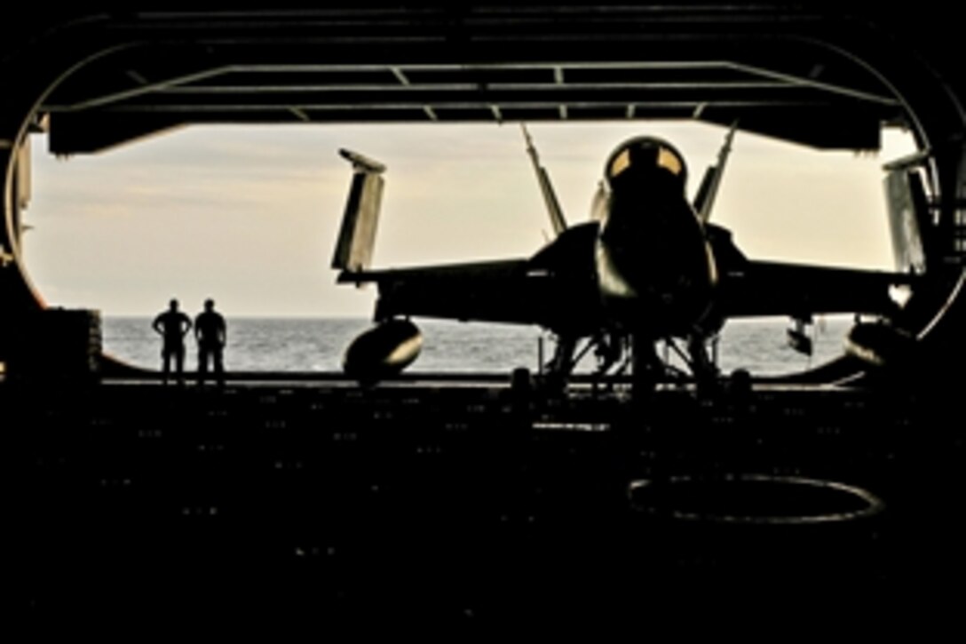 U.S. sailors watch the sunset from the hangar bay of the aircraft carrier USS Carl Vinson under way in the Arabian Sea, Jan. 21, 2012. The Carl Vinson and Carrier Air Wing 17 are deployed to the U.S. 5th Fleet area of responsibility. 