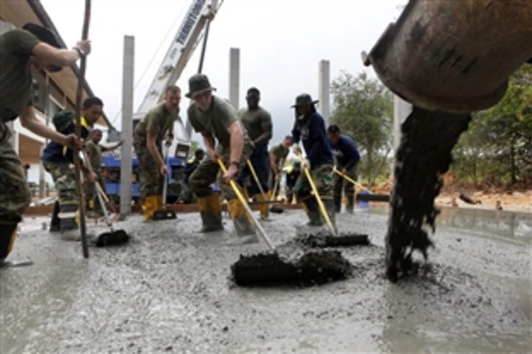 U.S. Marines along with Royal Thai Navy sailors and Indonesian forces pour concrete over a foundation at the Ban Khlong Bangbor School as part of Cobra Gold 2012 in Rayong, Thailand, Jan. 20, 2012. The Marines are assigned to Marine Wing Support Squadron 172. 