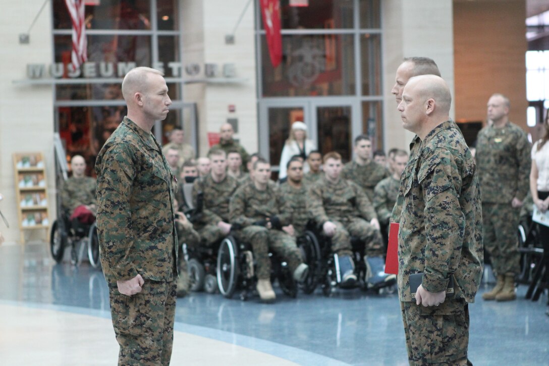 Wounded, ill and injured Marines with the U.S. Marine Corps Wounded Warrior Regiment look on as Sgt. Maj. John Ploskonka stands at attention in front of Col. John Mayer, Wounded Warrior Regiment commanding officer and Sgt. Maj. Joseph E. VanFonda during a post and appointment ceremony Jan. 23, at the National Museum of the Marine Corps here.  During the ceremony Sgt. Maj. Ploskonka passed his duties as regimental sergeant major of the Wounded Warrior Regiment to Sgt. Maj. VanFonda.  Ploskonka was selected to serve as the sergeant major of the Marine Corps Installations Command, Arlington, Va.