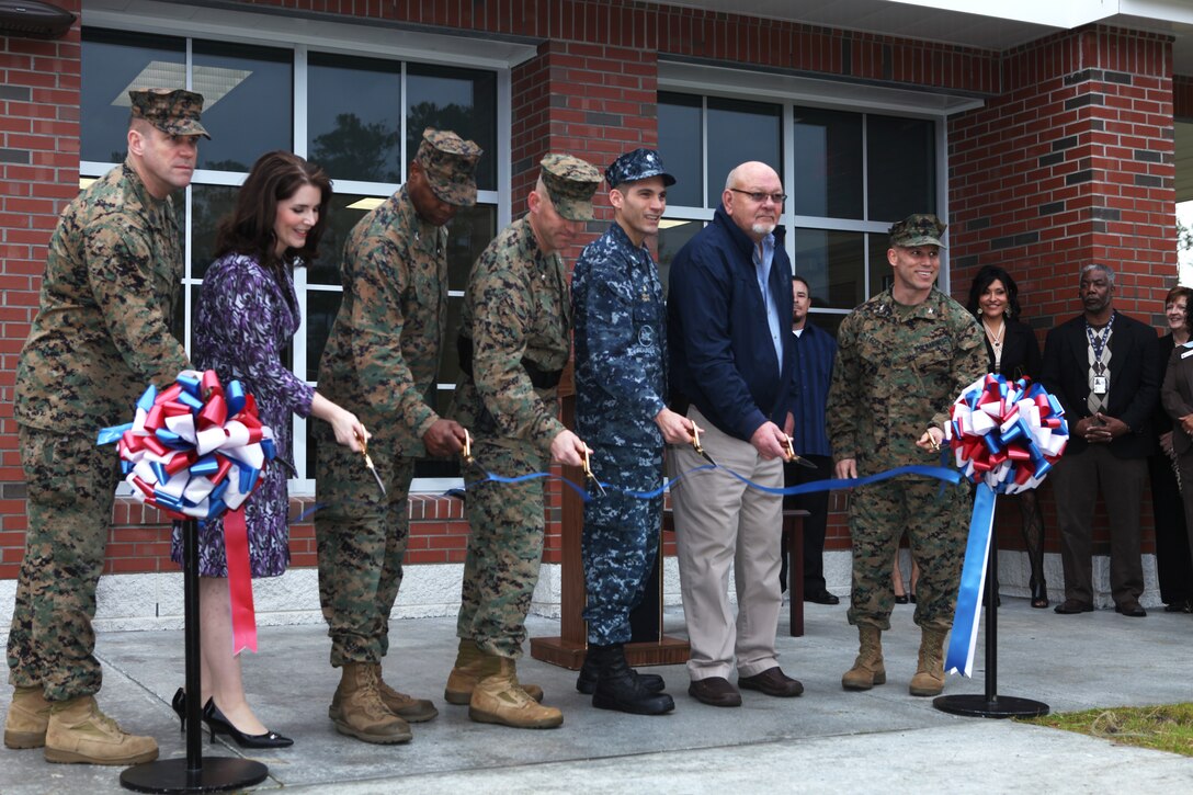 Officials representing Marine Corps Base Camp Lejeune, the Provost Marshal’s Office, the Office in Charge of Construction and Marine Corps Installations East gather for a photo during the ribbon cutting of the new and improved visitor’s center near the recently erect guard shack and front gate, Jan. 24.