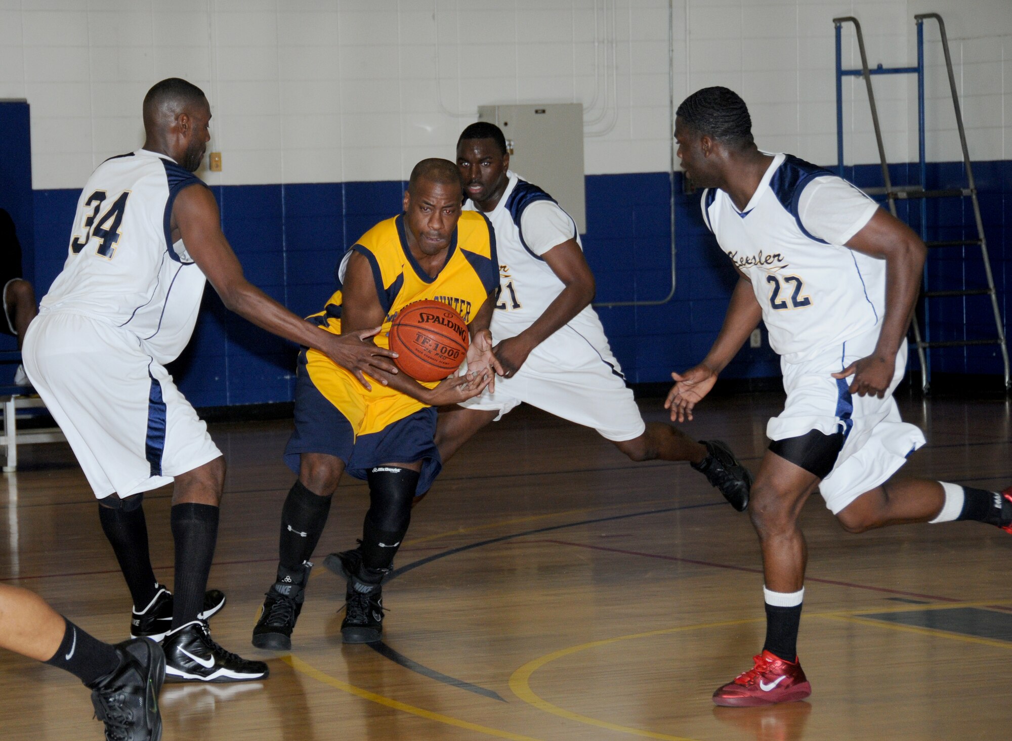 Jason Webb, Maxwell-Gunter Air Force Base, Ala., attempts to gain control of the basketball as Keesler Dragons Ray Williams, Tony Whitley and Quameir Harding surround him during a Southeastern Military Athletic Conference varsity basketball game Jan. 21, 2012, at the Blake Fitness Center, Keesler Air Force Base, Miss.  The Maxwell-Gunter Warriors defeated the Keesler Dragons, 73-69.  (U.S. Air Force photo by Kemberly Groue)