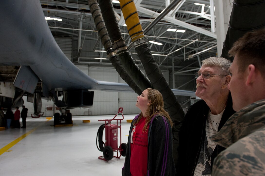 Ed Butler, a medically-retired U.S. Army veteran, and his granddaughter, Makennah Woods, admire a B-1B while Staff Sgt. Courtney Armstrong, 28th Aircraft Maintenance Squadron crew chief, provides information during a tour at Ellsworth Air Force Base, S.D., Jan. 17, 2012. Butler requested a visit with the B-1 as one of his last wishes after diagnosed with terminal cancer. (U.S. Air Force photo by Airman 1st Class Kate Thornton/Released)