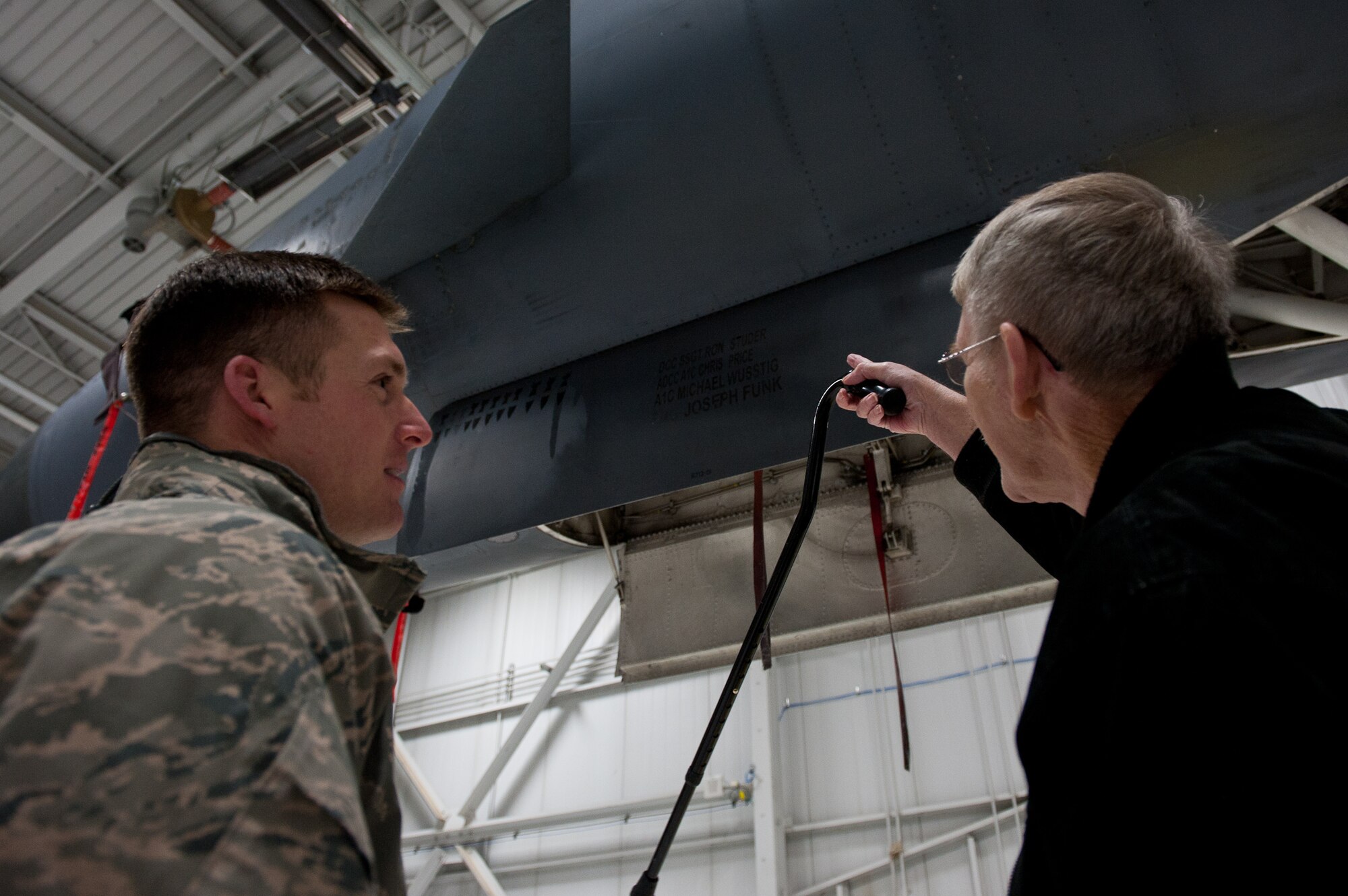Ed Butler, a medically-retired U.S. Army veteran, asks questions about a part of a B-1B to Staff Sgt. Courtney Armstrong, 28th Aircraft Maintenance Squadron crew chief, during a tour at Ellsworth Air Force Base, S.D., Jan. 17, 2012. A retired military member diagnosed with terminal cancer, Butler was able to fulfill one of his last wishes, touring a B-1B. (U.S. Air Force photo by Airman 1st Class Kate Thornton/Released)