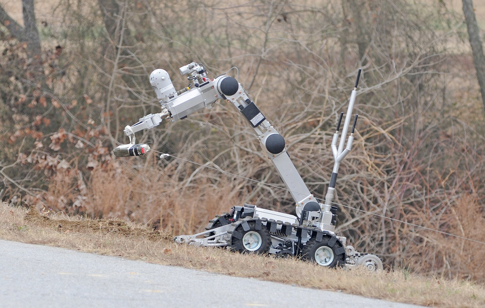 An Air Force medium sized robot places a simulated charge on a mock improvised explosive device during a convoy exercise at Seymour Johnson Air Force Base, N.C., Jan. 23, 2012. During this training scenario the explosive ordnance disposal team simulates removing explosive charges to allow a convoy to continue on its route. (U.S. Air Force photo/Senior Airman Gino Reyes)
