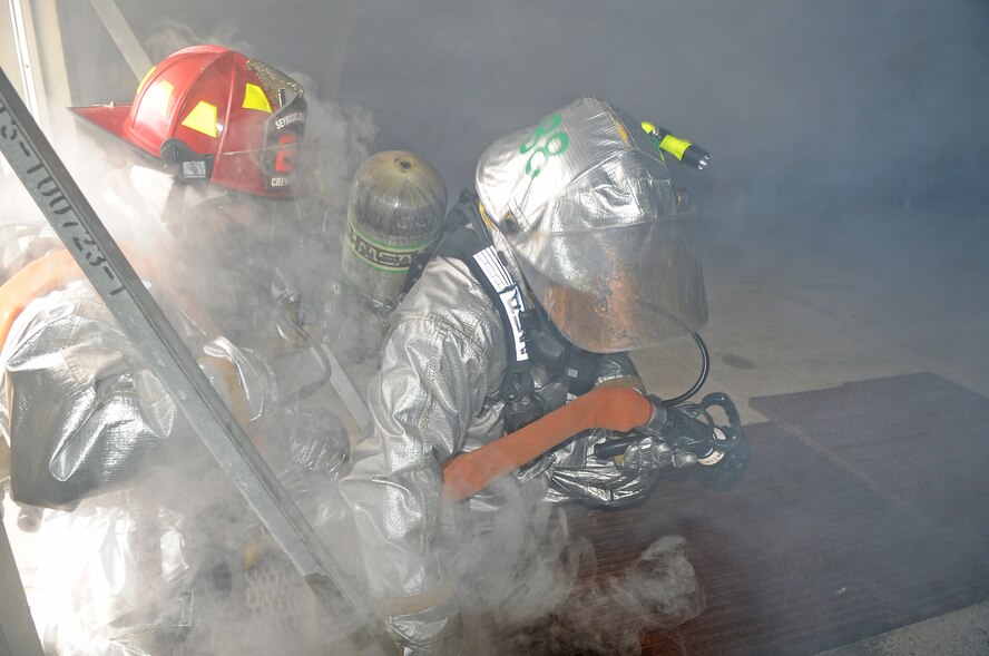 Tech. Sgt. Anthony Costin and Airman Matt Gernaat clear a building during a simulated fire as part of the 4th Civil Engineer Squadron internal training exercise at Seymour Johnson Air Force Base, N.C., Jan. 23, 2012. The fire department simulated fires to train firefighters on how to clear and remove injured personnel from burning buildings and aircraft. Costin and Gernaat  are both 4th CES firefighters. Costin hails from Big Creek, Miss; Gernaat hails from Plainwell, Mich. (U.S. Air Force photo/Senior Airman Gino Reyes)