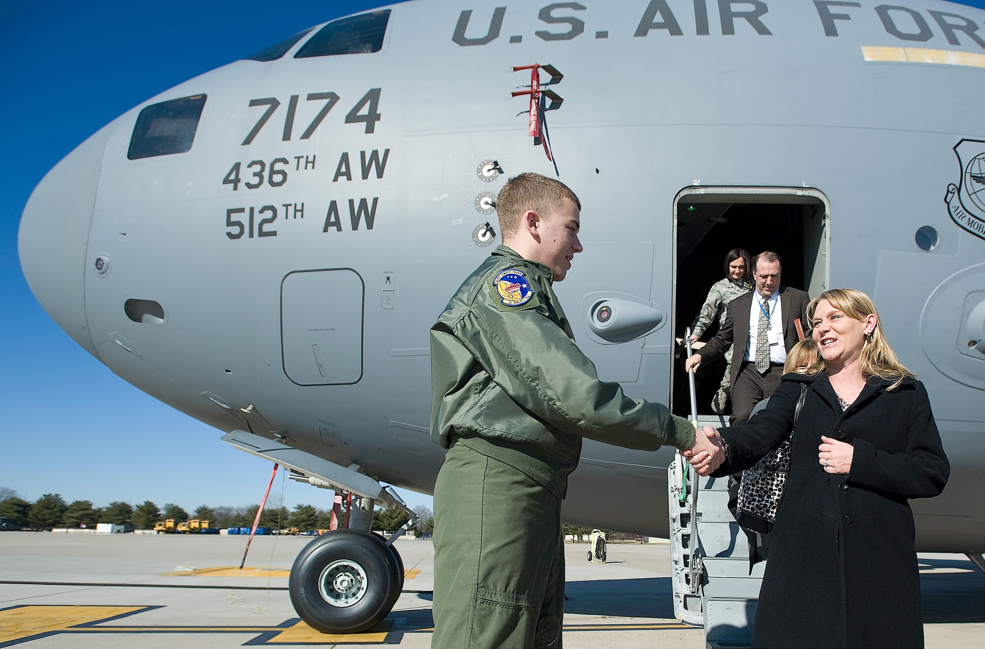 Jesse Helmick, program supervisor with the Delaware Early Childhood Center, shakes hands with Airman 1st Class Steven Conover, loadmaster with the 3rd Airlift Squadron, after the base’s first Military 101 for Educators Tour Jan. 19, 2012, at Dover Air Force Base, Del. Educators from across Kent County, Del., came to Dover AFB to familiarize themselves with base programs meant to benefit military children. (U.S. Air Force photo by Airman 1st Class Samuel Taylor)