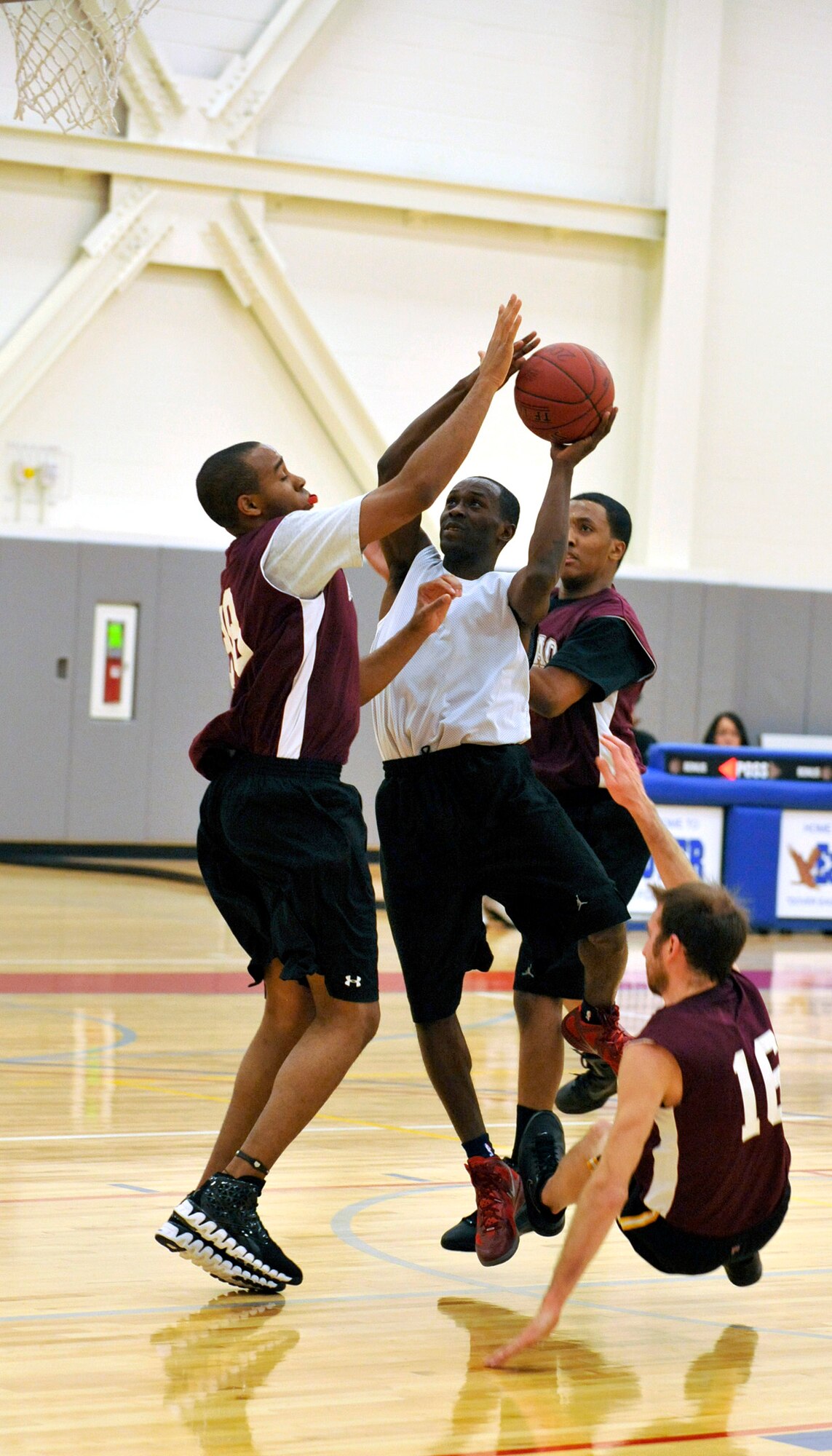 436th Security Forces Squadron guard Matthew Mitchell drives to the hoop while Air Force Mortuary Affairs Office players defend during an intramural basketball game at the base fitness center Jan. 19, 2012, at Dover Air Force Base, Del. Mitchell scored a game-high 22 points as he led the Cops to a 61-30 blow-out victory against AFMAO. (Photo by Tech. Sgt. Chuck Walker)
