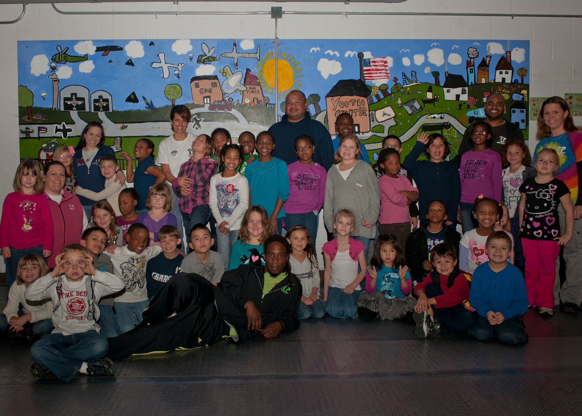 Children and staff of the Moody youth program gather for a photo at the Airman and Family Readiness Center, Moody Air Force Base, Ga., Jan. 20, 2012. The youth program offers many recreational activities such as sports, cooking classes, computers and homework lab. Recently, the facility was awarded the Air Combat Command Youth Programs of the Year award in recognition of their quality care for military and Department of Defense civilian dependants. (U.S. Air Force photo by Senior Airman Eileen Meier/Released)
