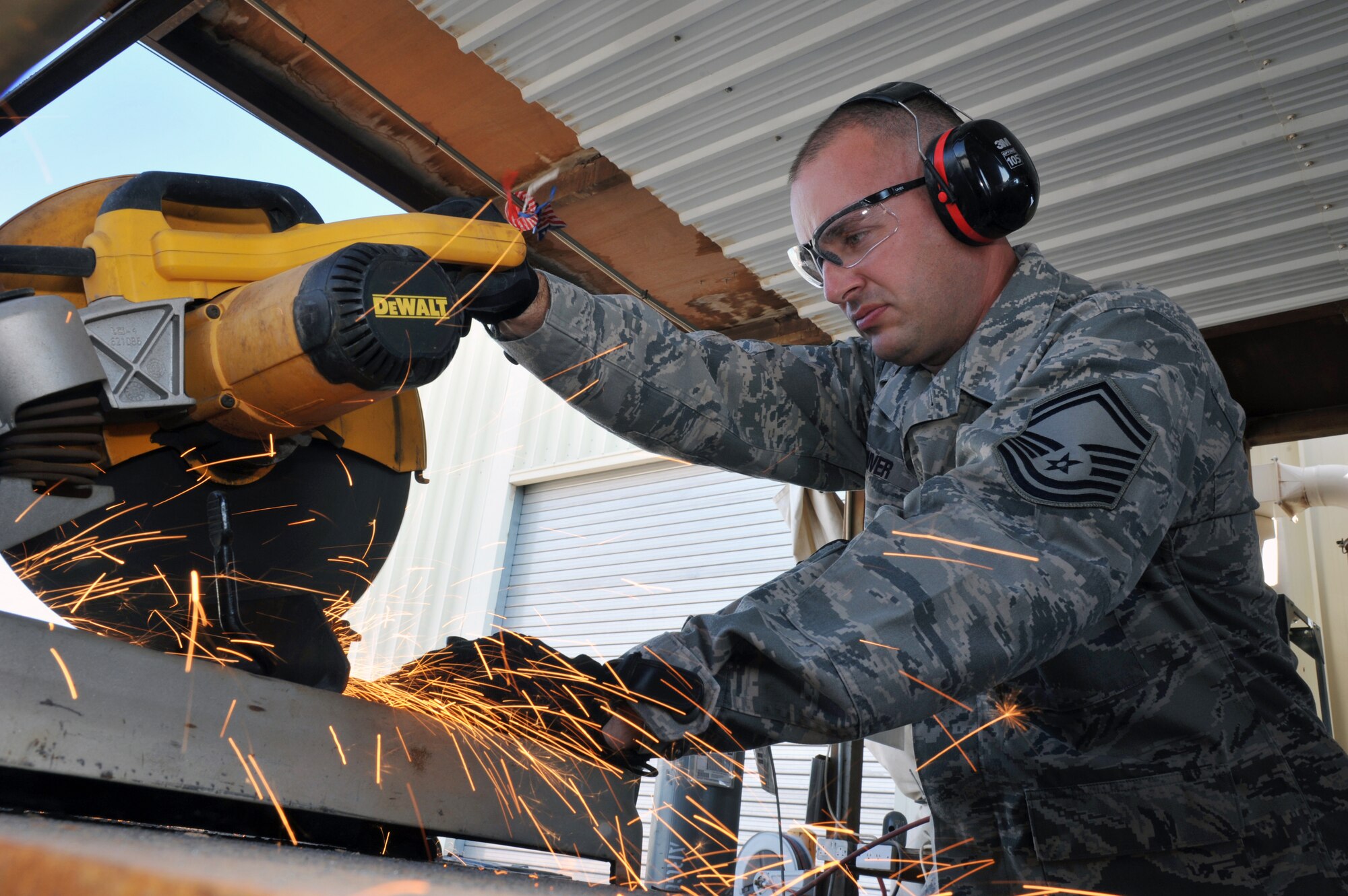 U.S. Air Force Senior Master Sgt. Kurt Huver cuts a piece of metal tubing that will be used for fabricating poles for telephone boxes in Commando Village on Nov. 23, 2011. He is working as a mission support Specialist with the 386th Expeditionary Civil Engineer Squadron at an undisclosed location in Southwest Asia. Huver was deployed from 133rd Civil Engineer Squadron, St. Paul, Minn. He was selected as the Outstanding Senior Non-Commissioned Officer of the Year for the 133rd Airlift Wing and the State of Minnesota. USAF photo by Master Sergeant Carlotta Holley