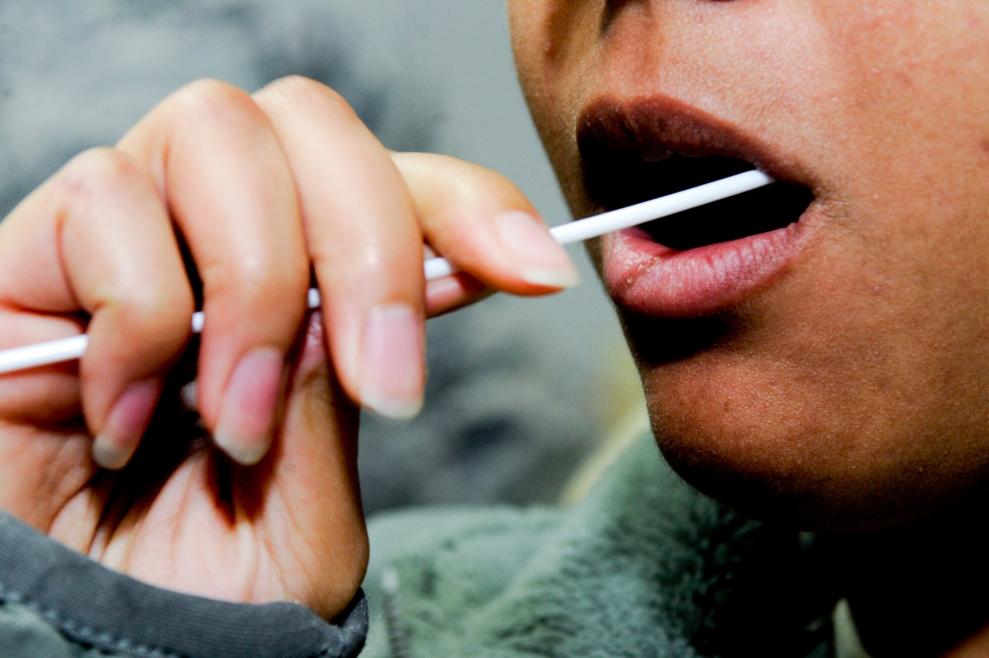 A possible donor swabs the inner cheek to collect a DNA sample during a bone marrow registry drive at an undisclosed location in Southwest Asia, Jan. 22, 2012. In addition to a completed registration form, four cotton swabs of DNA were needed to become a donor. The 332nd Air Expeditionary Wing has registered more than 400 donors during the last two bone marrow registry drives. (U.S. Air Force photo by Staff Sgt. Joshua J. Garcia/Released)