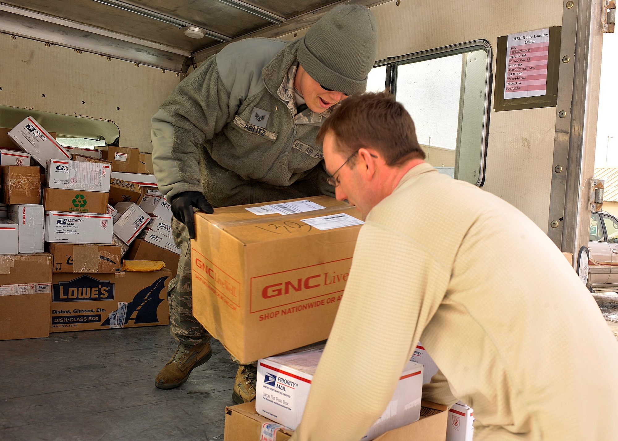BAGRAM AIRFIELD, Afghanistan—Tech. Sgt. James Casselman accepts packages from Staff Sgt. Jennifer Albitz  at Bagram Airfield, Afghanistan, Jan. 24, 2012. Casselman is a communications navigation systems craftsman with the 455 Expeditionary Aircraft Maintenance Squadron, and Albitz is the assistant noncommissioned officer in charge of the Air Force Mail Distribution Center. (U.S. Air Force photo/ Airman 1st Class Ericka Engblom)
