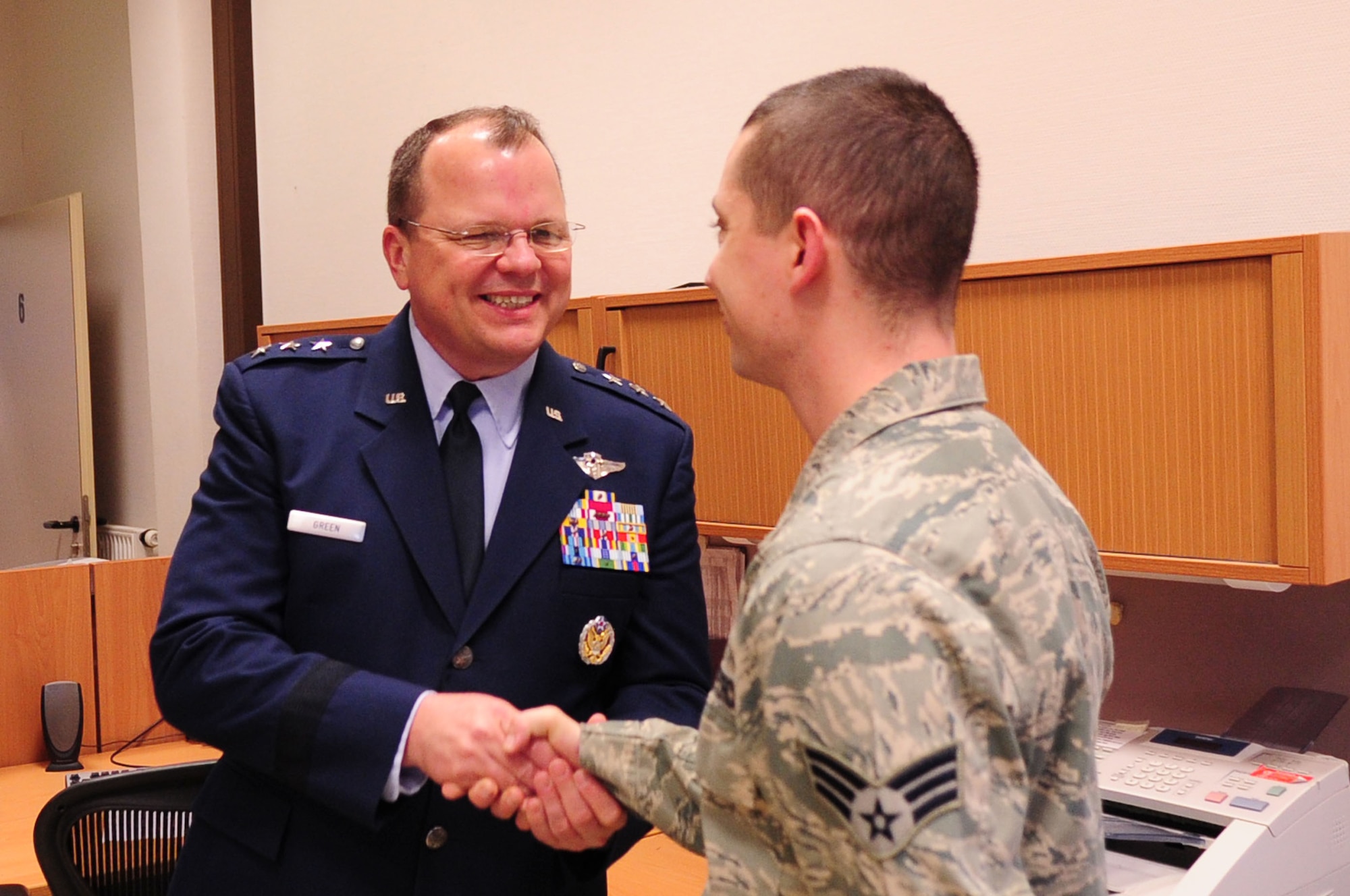 Lt. Gen. Charles B. Green, Air Force surgeon general, coins Senior Airman Sean Burnett, 86th Aerospace Medical Squadron, during his visit to the 86th Contingency Aeromedical Staging Facility, Ramstein Air Base, Germany, Jan. 23, 2012. The purpose of his visit was to assess the capabilities of the 86th Medical Group and to visit with Airmen from the unit. (U.S. Air Force photo by Senior Airman Brittany Perry)
