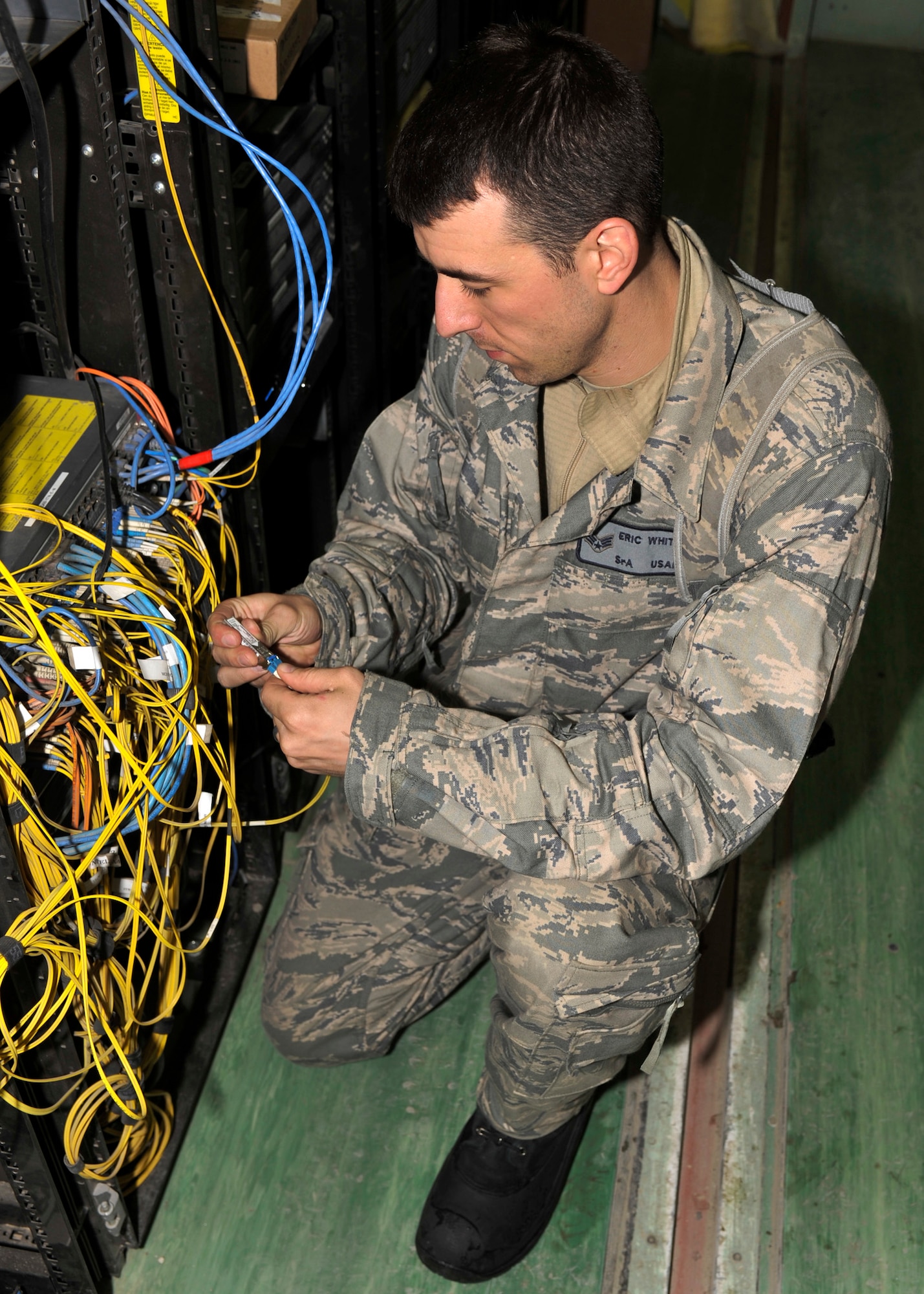 BAGRAM AIRFIELD, Afghanistan—Senior Airman Eric White fixes a portion of the cables that control the non-classified internet protocol router network at Bagram Airfield, Afghanistan, Jan. 23, 2012. White is a network technician 455th Expeditionary Communications Squadron and is deployed from Joint Base Langley-Eustis, VA. (U.S. Air Force photo/ Airman 1st Class Ericka Engblom)