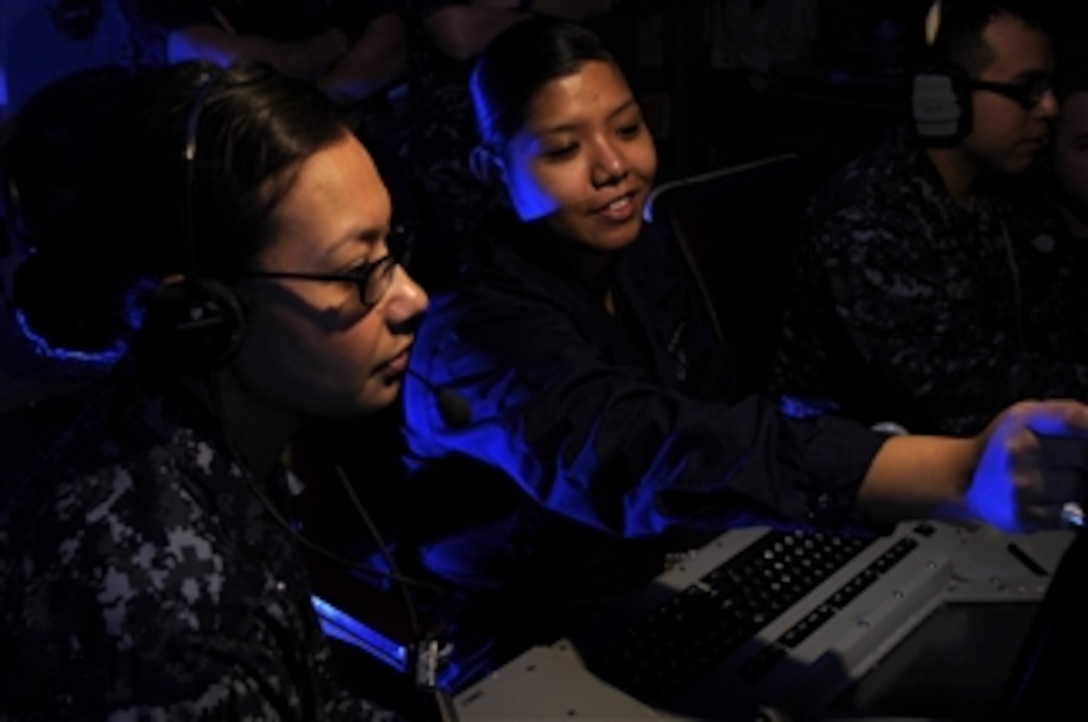 U.S. Navy Petty Officer 2nd Class Katherine Newquist (left) and Seaman Apprentice Leizle Aspili analyze radar frequencies in the electronic warfare module aboard the aircraft carrier USS Carl Vinson (CVN 70) in the Arabian Sea on Jan. 20, 2012.  The Carl Vinson and Carrier Air Wing 17 are deployed to the U.S. 5th Fleet area of responsibility.  