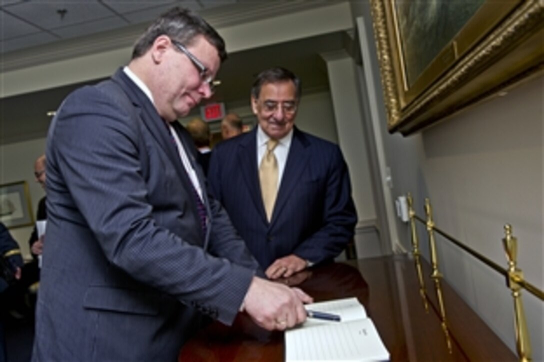 U.S. Defense Secretary Leon E. Panetta, right, looks on as Czech Defense Minister Alexandr Vondra signs the guest book at the Pentagon, Jan. 24, 2012.