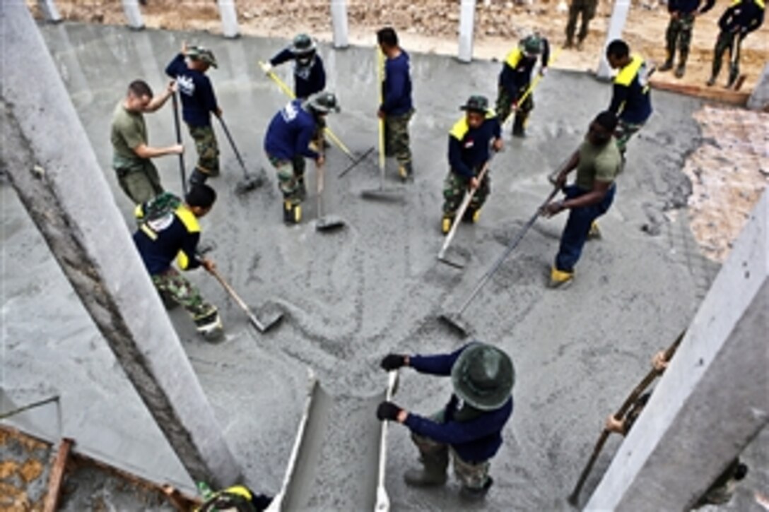 U.S. Marines along with Royal Thai Navy sailors and Indonesian forces pour concrete over a foundation at the Ban Khlong Bangbor School as part of Cobra Gold 2012 in Rayong, Thailand, Jan. 20, 2012.