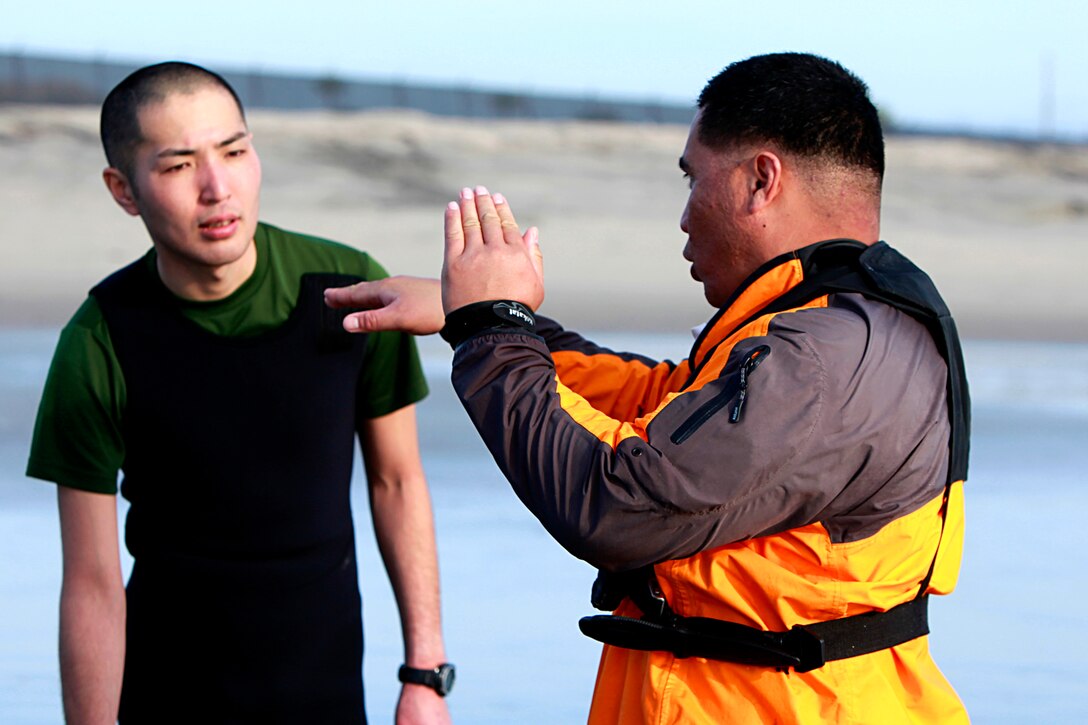Gunnery Sgt. Sione Kefu, the director of the coxswain’s course at Expeditionary Warfare Training Group Pacific explains the importance of properly attaching gear to the combat rubber raid craft to a Japanese Soldier with the Western Army Infantry Regiment, Japanese Ground Self Defense Force conduct amphibious training at Naval Amphibious Base Coronado, Jan. 22. The JGSDF are here to participate in Exercise Iron Fist with the 15th Marine Expeditionary Unit, a unique training opportunity for both services. Boats are one of many amphibious means the Marine Corps uses to move troops ashore in an expeditionary manner. Marine Expeditionary Units are responsible to our nation as a 911 force in readiness.