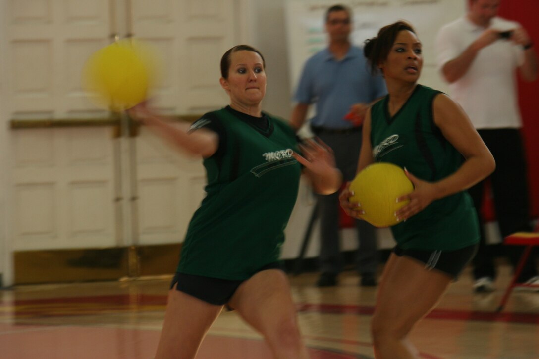 Lance Cpl. Kayla Hickingbottom, Training Regiment team 1 team member, throws a dodge ball at Headquarters and Service Battalion team 2 team members Jan. 24 during the Women's Dodge Ball Tournament aboard Marine Corps Recruit Depot San Diego. Julica Evans, RTR 1 team member, followed Hickingbottomes lead aiming and throwing her ball at H&Q 2. RTR 1 showed no mercy taking home MCRD's first Women's Dodge Ball Tournament against H&S Bn. 2.