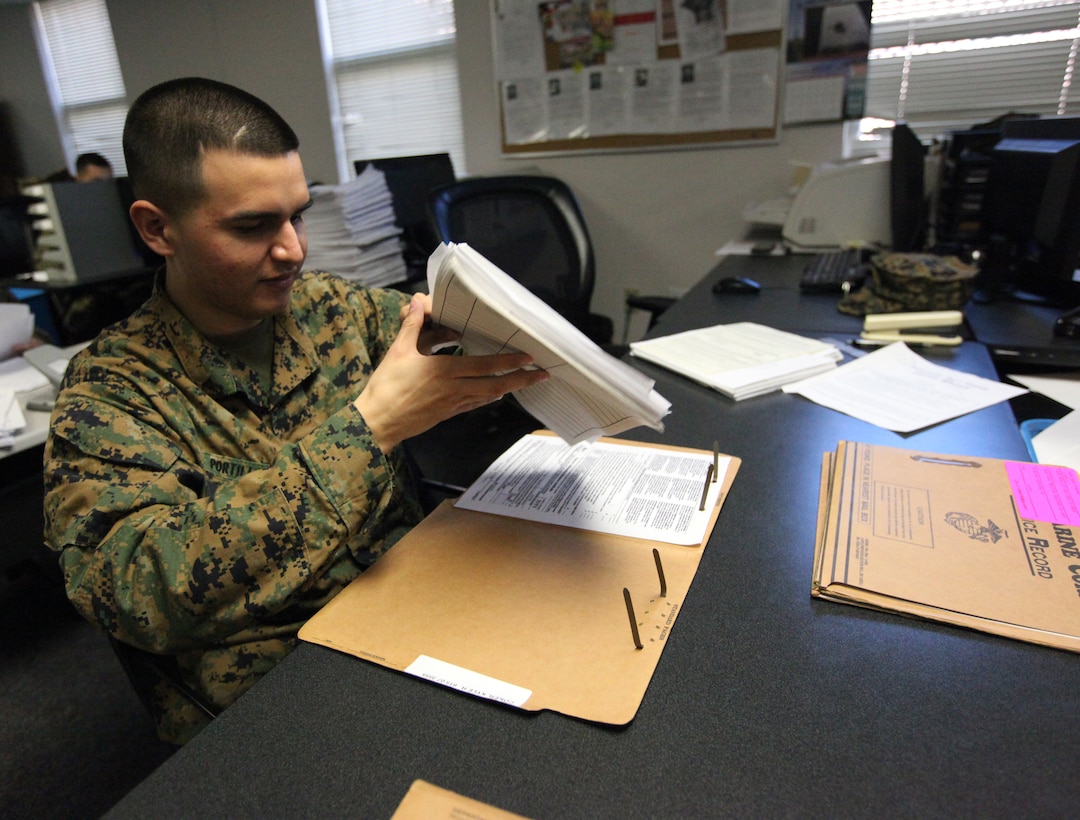 ::r::::n::An administrative clerk in the service record book section, Installation Personnel Administration Center aboard Marine Corps Base Camp Lejeune, verifies if documents from SRBs were updated on Marine Online, recently. The process of converting the SRBs to an Official Military Personnel File online, also known as an E-record, took 10 weeks for IPAC, MCB Camp Lejeune to complete. ::r::::n::