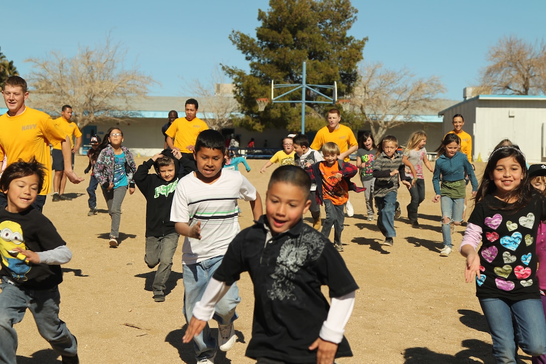Sailors from the Robert E. Bush Naval Hospital run laps with kids from Joshua Tree Elementary School in the kids physical education time Jan. 25, 2012.