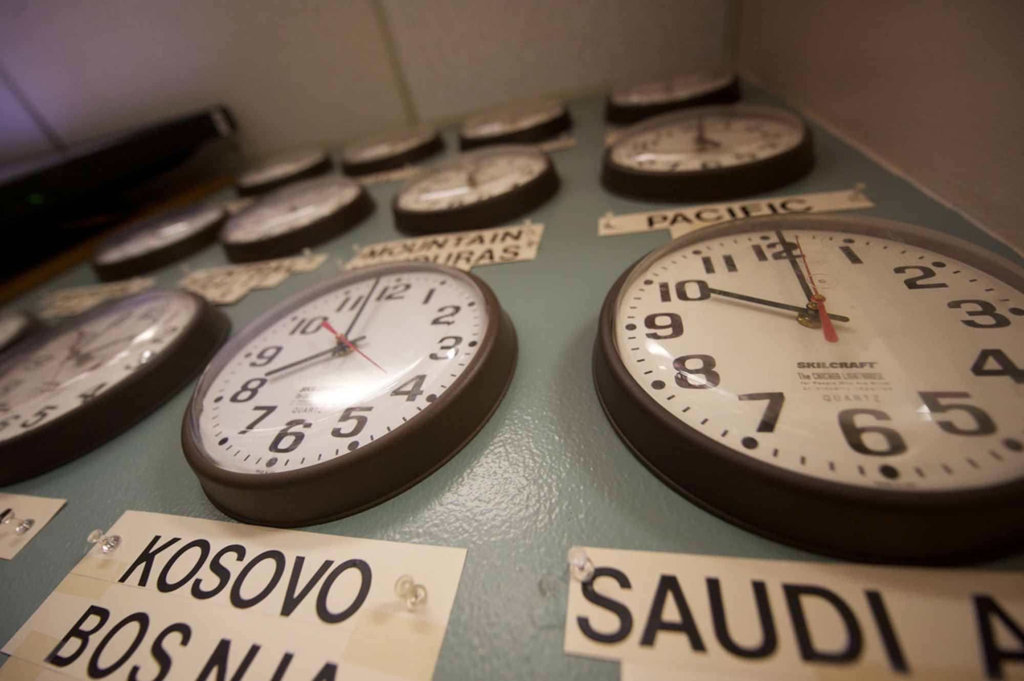 A wall of clocks at Joint Base Elmendorf-Richardson Telephone Operations helps operators keep time with locations their callers may be deployed to. (U.S. Air Force photo/David Bedard)