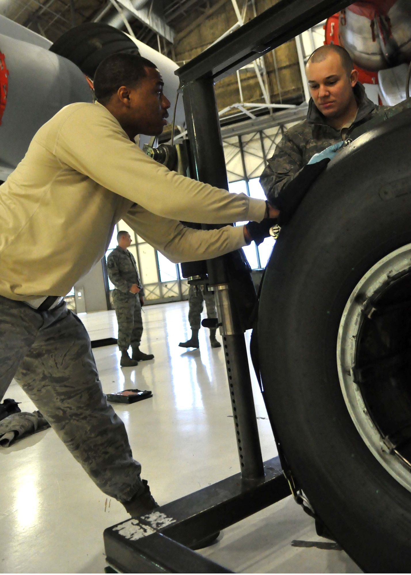 Staff Sgts. Dequan McHatten, left, and Justin Miller, 62nd Aircraft Maintenance Squadron crew chiefs, maneuver a new tire toward a C-17 Globemaster III Jan. 17, 2012, at Joint Base Lewis-McChord, Wash. Part of a crew chief’s responsibilities include maintaining, servicing and inspecting aircraft and aerospace support equipment as well as using technical data to diagnose and solve maintenance problems on aircraft systems. (U.S. Air Force photo/Airman 1st Class Leah Young)