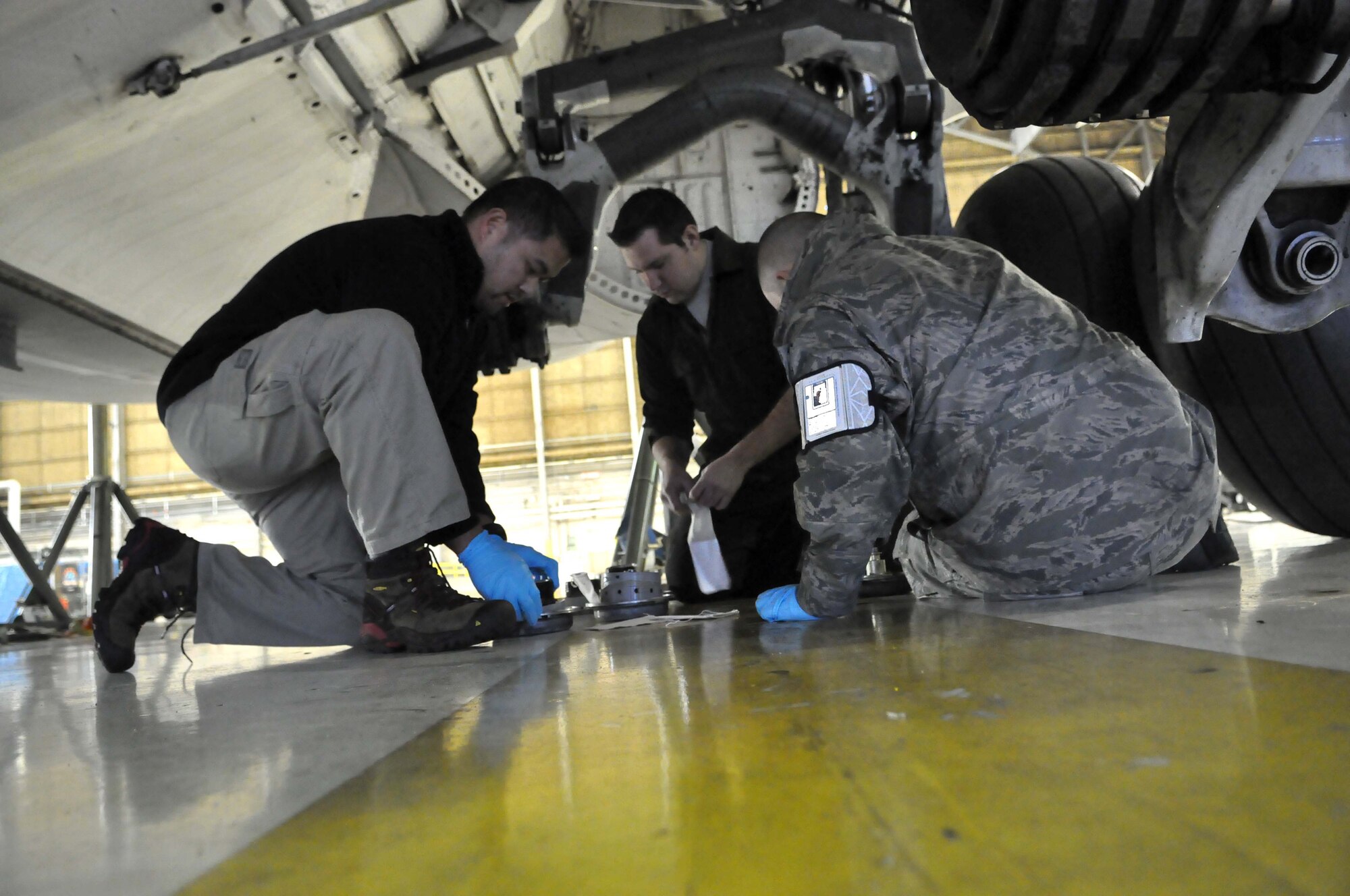 A civilian, active duty Airman and Reservist work together while preparing to change a tire on a C-17 Globemaster III Jan. 17, 2012, at Joint Base Lewis-McChord, Wash. (U.S. Air Force photo/Airman 1st Class Leah Young)
