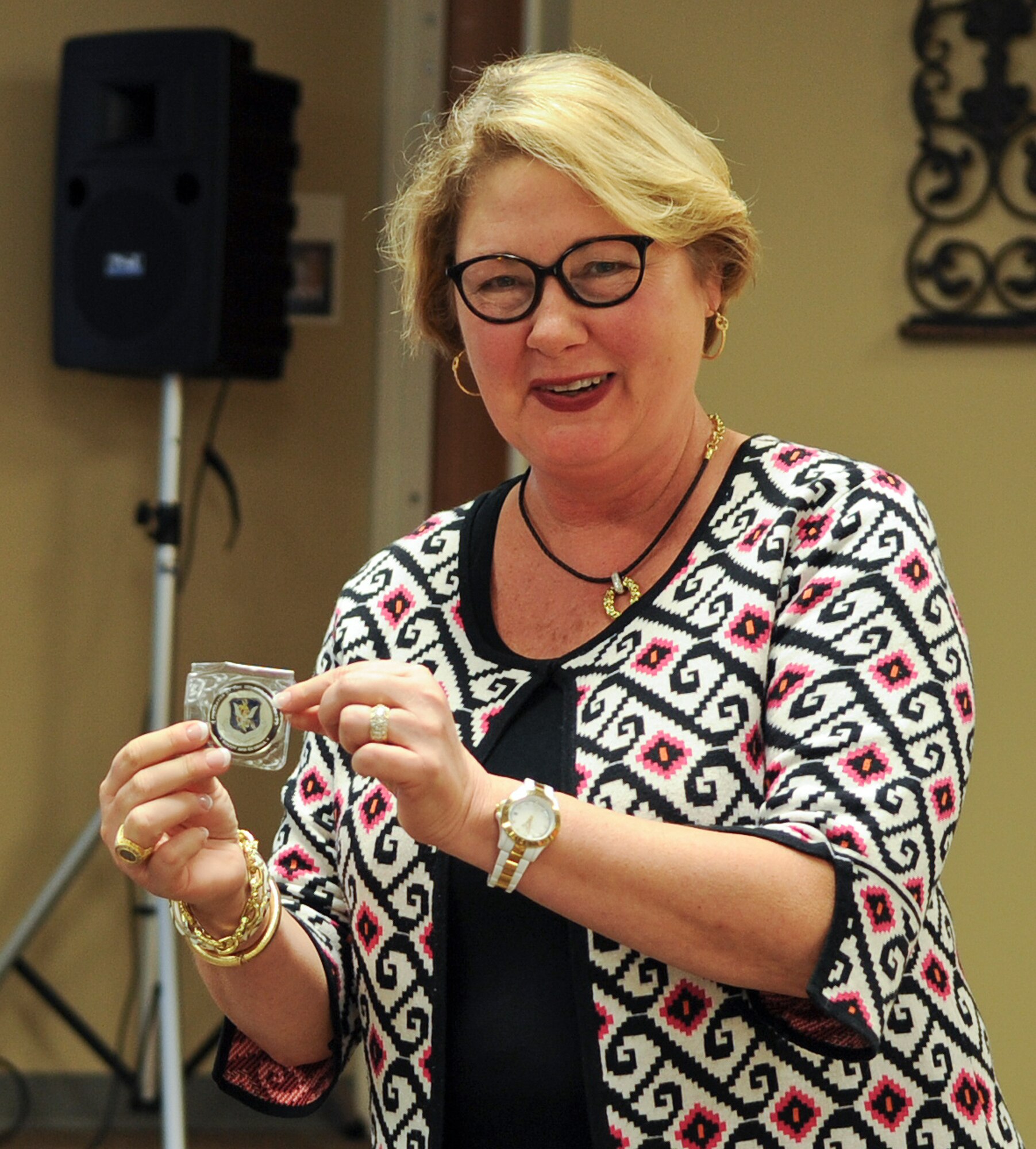 Susan B. Johnson, director of Program Development for Lowndes Drug Action Council, holds up an appreciation coin given to her by Ann Lukens, Moody School Liaison Officer, during an anti-bullying luncheon at Moody Air Force Base, Ga., Jan. 25, 2012. Johnson prepared a presentation about the dangers of bullying and how to prevent it in elementary and middle schools. (U.S. Air Force photo by Airman 1st Class Olivia Dominique/Released)