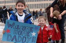 Zachary and Rebekah Ferron, awaits the return of their father Senior Airman Brandon Ferron, 34th Air Maintenance Squadron weapons loader at the Pride Hanger at Ellsworth Air Force Base, S.D., Jan. 25, 2012. Airmen returned home from a six-month deployment of supporting mission operations in Southwest Asia. (U.S. Air Force photo by Airman 1st Class Zachary Hada/Released)