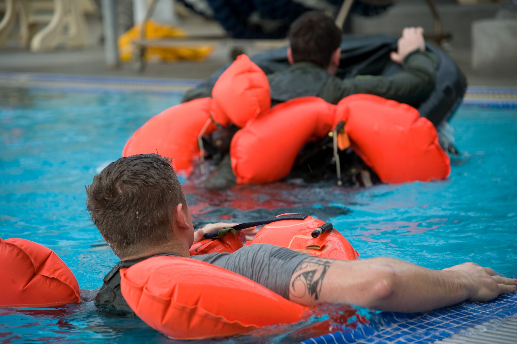 A survival instructor watches a student demonstrate how to get into a raft during a water survival class Jan. 24. (U.S. Air Force photo/Airman 1st Class Nicole Leidholm)

