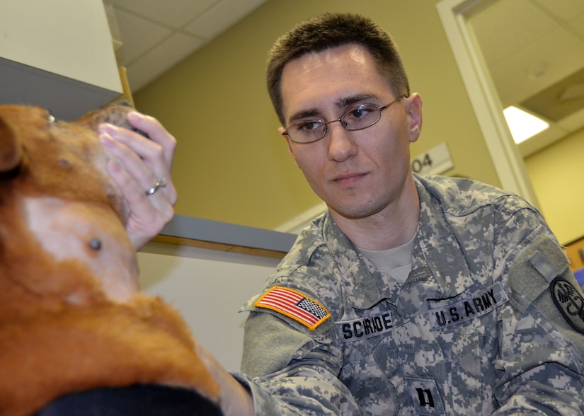 Army Capt. (Dr.) Andrew Schrader investigates a lump on a dog’s throat during an appointment at the Joint Base Charleston – Air Base Veterinary Treatment Facility. The VTF provides the same high quality veterinary care to active duty and retirees pets that is expected from civilian clinics. (U.S. Air Force photo / Airman 1st Class Tom Brading)