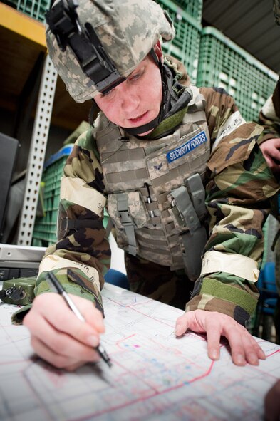 U.S. Air Force Staff Sgt. Matthew Milne, security forces specialist, 140th Security Forces Squadron, plots cordons on a map as part of an unexploded ordinance scenario during an Operational Readiness Exercise at Buckley Air Force Base, Colo., Jan. 21, 2012. The exercise evaluates service members’ mission readiness for real world deployments. (U.S. Air Force photo/Master Sgt. John Nimmo, Sr.) 