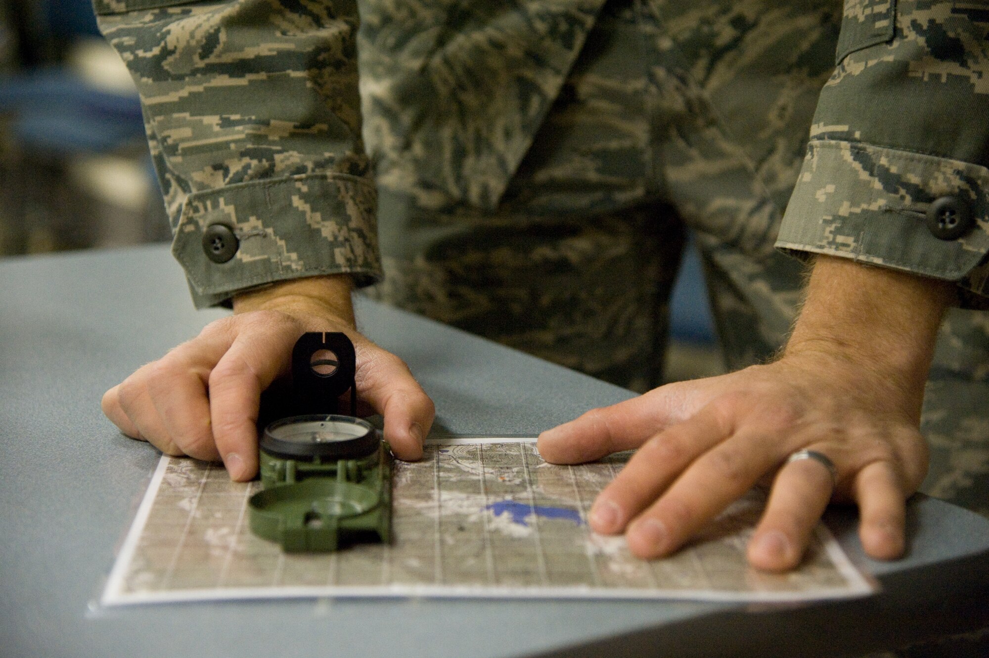 A survival instructor shows how to use a map and a compass during a training session Jan. 24. (U.S. Air Force photo/Airman 1st Class Nicole Leidholm)