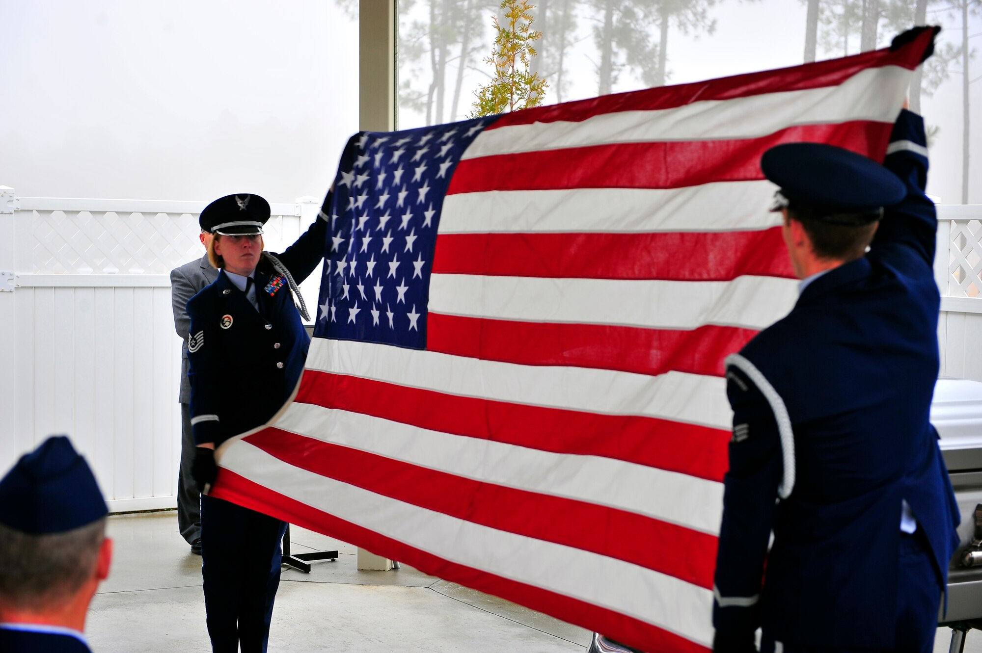 U.S. Air Force Tech Sgt. Rachel Hill, Honor Guard noncommissioned officer in charge and Senior Airman Stuart Brennan, unfold the U.S. flag for a funeral service at Ft. Jackson National Cemetery, S.C. Jan. 23, 2011. Shaw’s Honor Guard provides funeral service details, and other services to four states, 75 counties, and approximately five million residents. (U.S. Air Force photo/Senior Airman Neil D. Warner)(Released)