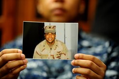 Petty Officer 1st Class Frank Newsom holds up a photo of himself when he was on his first Individual Augmentee deployment, Jan. 19 at Joint Base Charleston - Weapons Station. There were more than 8,000 Navy IA deployments last year taking Sailors to 14 different locations from Central America to the Middle East to serve in an array of different combat support roles. Newsom is preparing for another one-year IA to Afghanistan where he will provide protective services for a senior officer. Newsom is a Master-at-Arms at the 628th Security Forces Squadron.  (U.S. Air Force photo/ Staff Sgt. Nicole Mickle)  